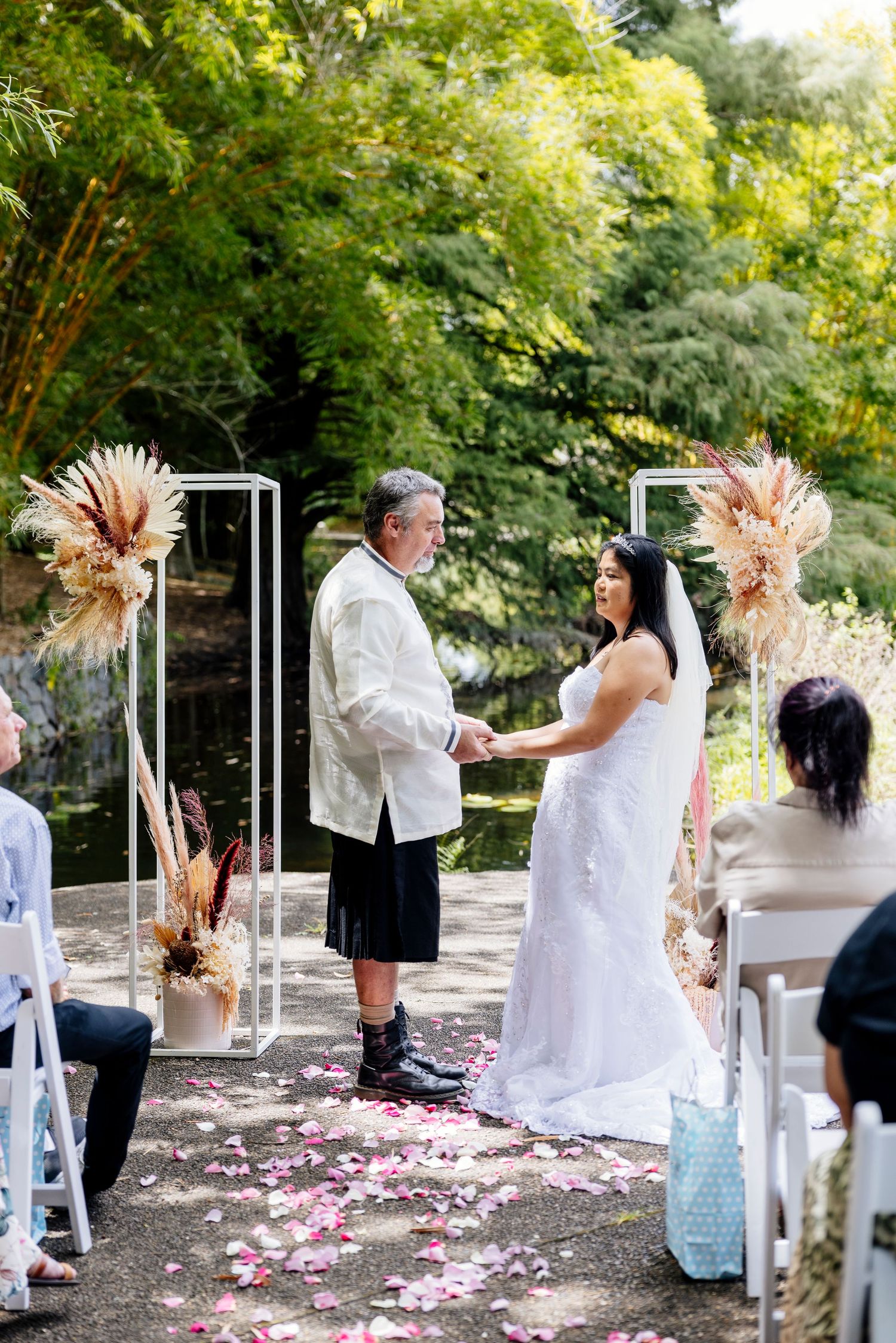 Intimate wedding ceremony in bright modern venue with white walls and circular skylight dome.