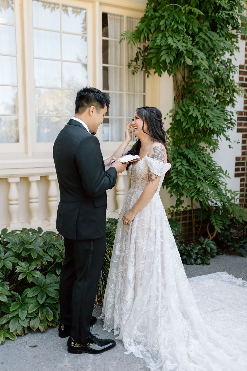 Outdoor wedding first look moment captured in a series of romantic photos against a white pillar backdrop with lush greenery.