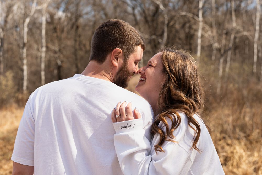 Romantic couple in matching white outfits embrace on a nature trail.
