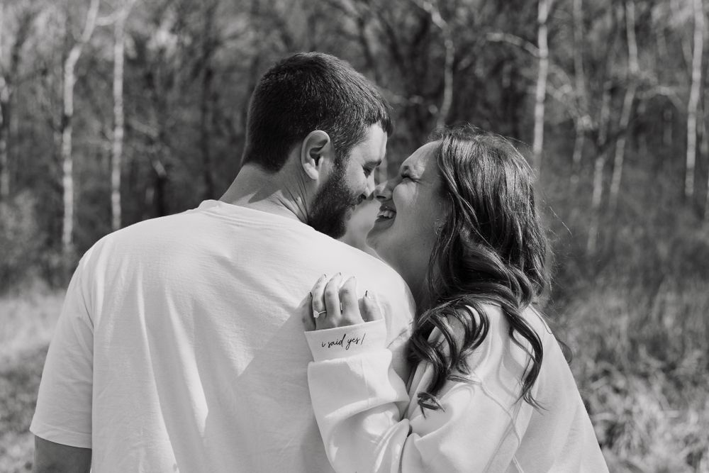 Black and white photo of couple sharing an intimate moment outdoors.