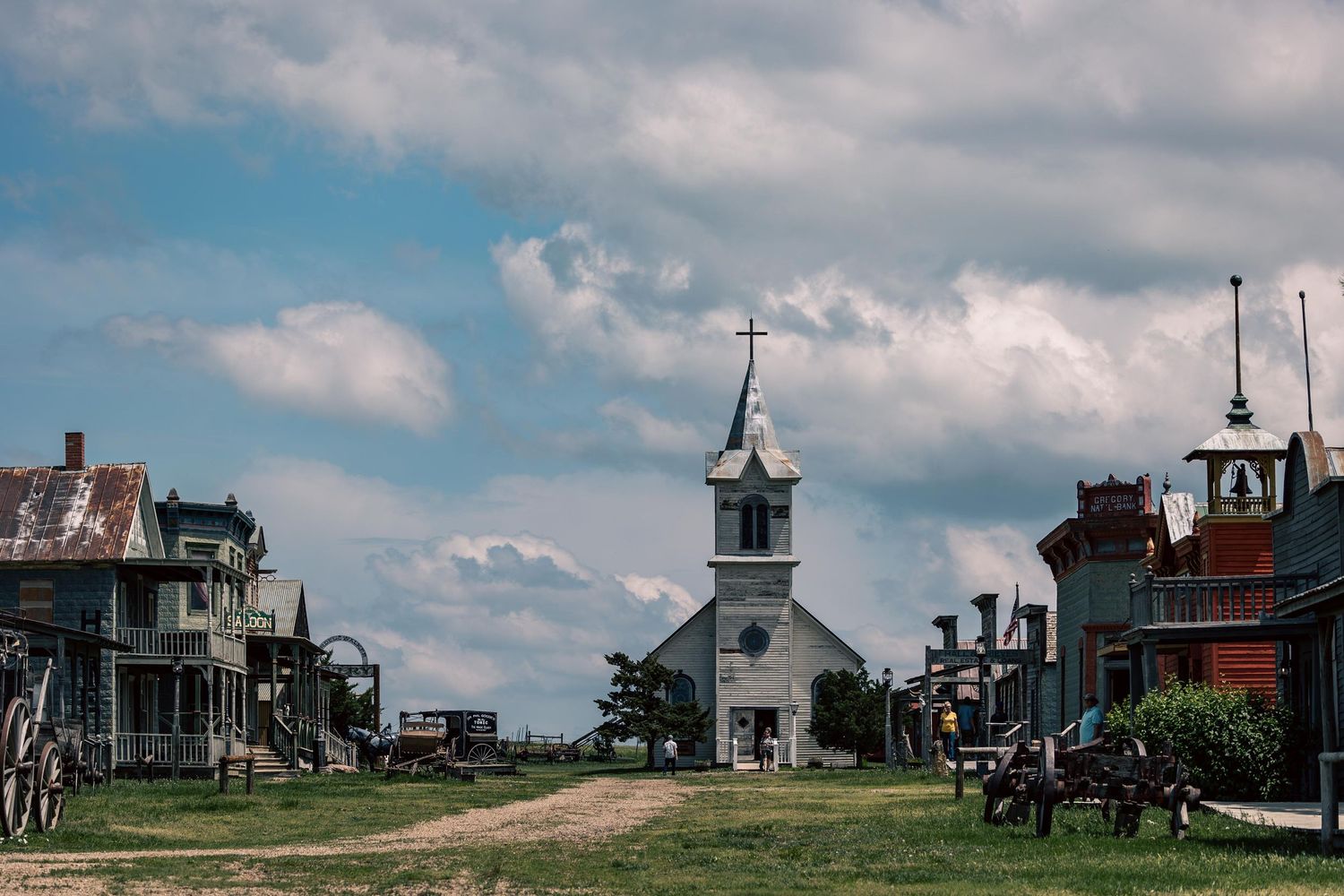 Historic white church with steeple on main street of old western town.