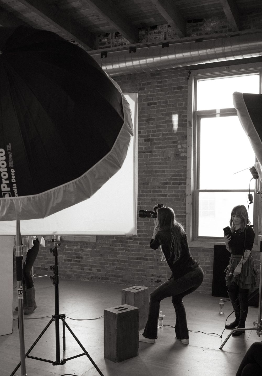 Studio photography setup with large softbox and silhouetted figures.