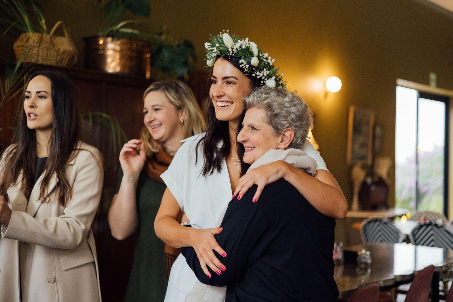 A group of people share a joyous moment together at an indoor gathering with warm lighting.