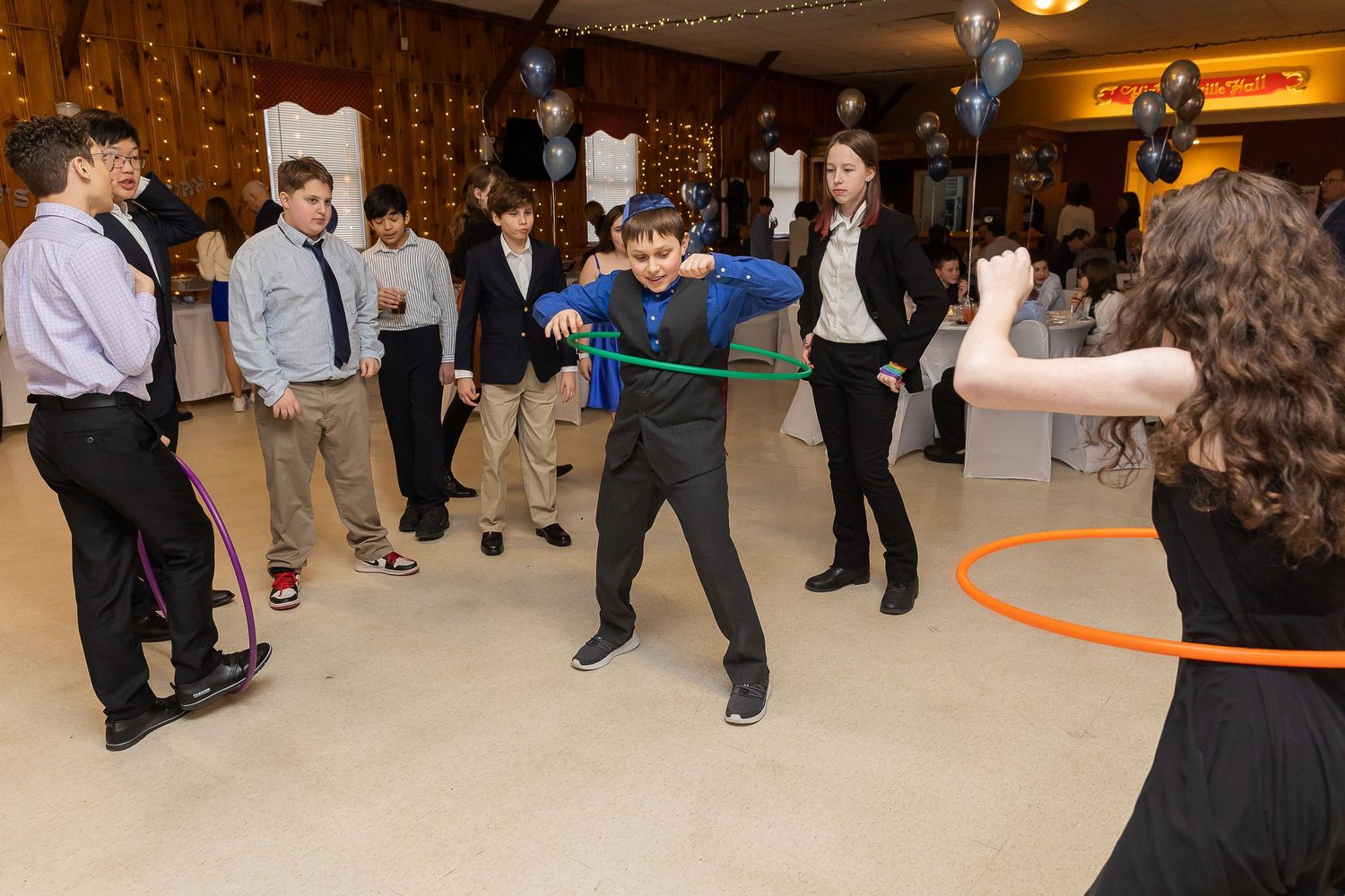 Celebratory dancing and festivities at a party with guests forming a circle on the dance floor.