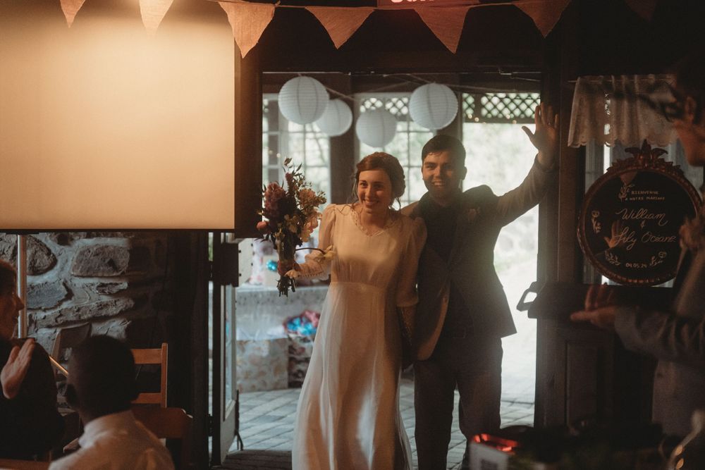 First dance moment at wedding reception with string lights and bunting decoration.