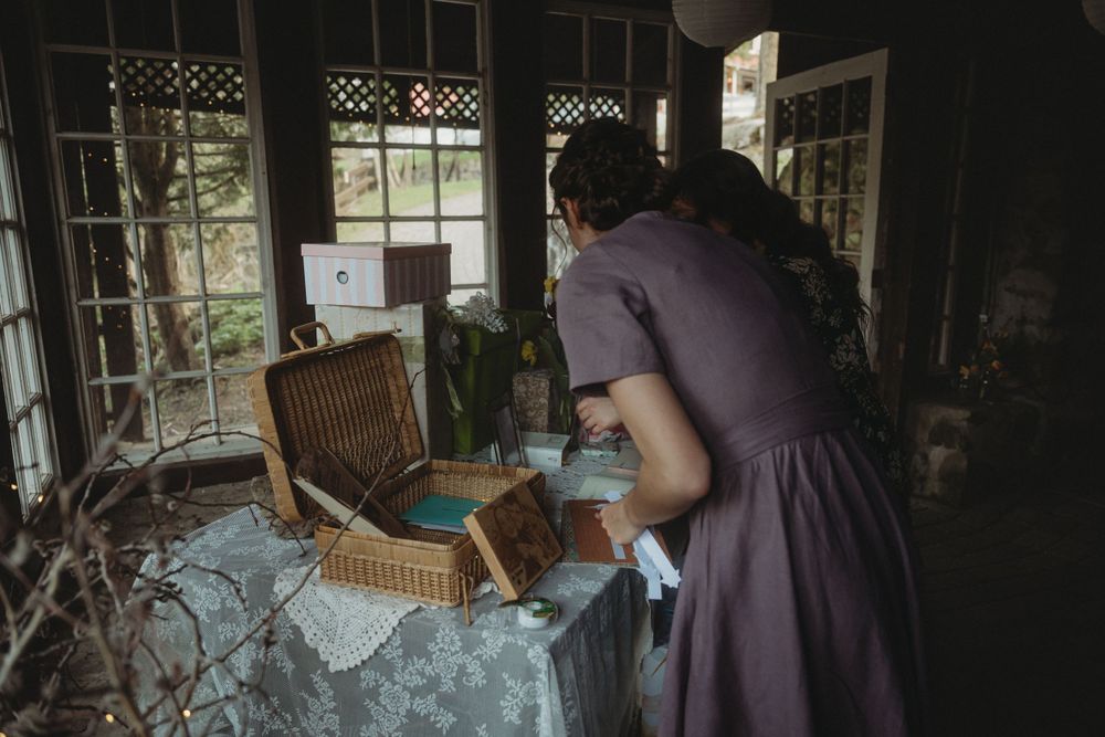 Guest book table setup at rustic wedding venue with vintage furniture and natural lighting.
