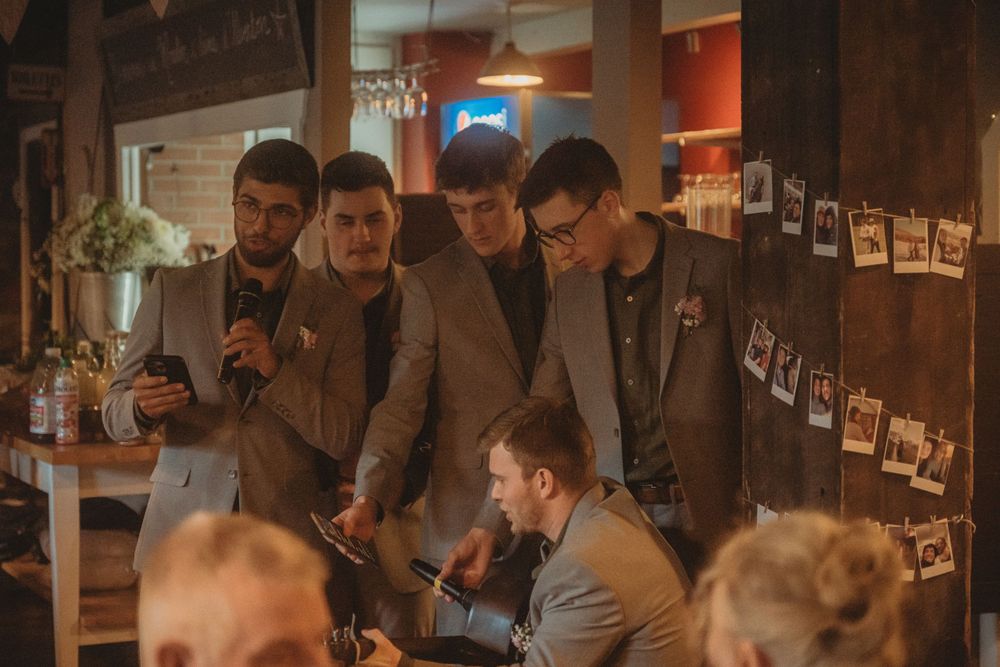 Group gathering at indoor reception with exposed brick walls and vintage decor.