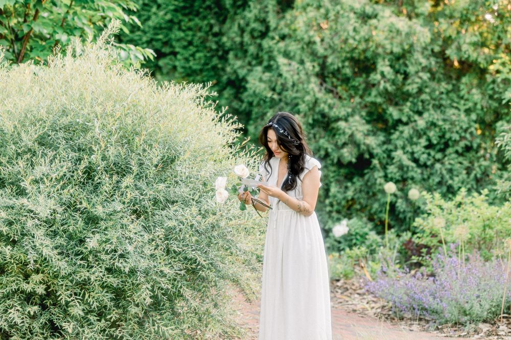 A garden portrait with white dress among blooming flowers and greenery.