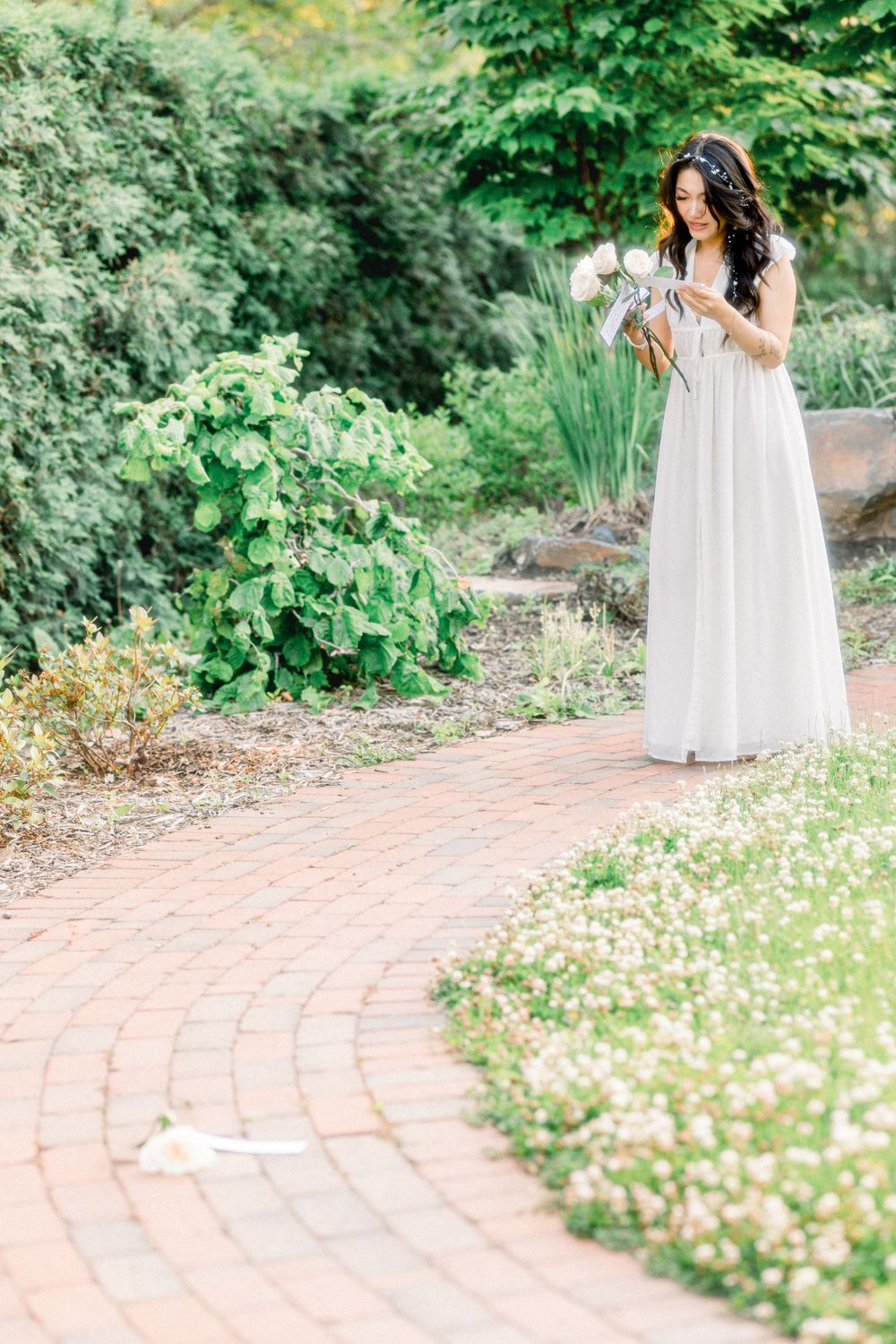 A romantic garden scene with brick pathway and delicate summer blooms.
