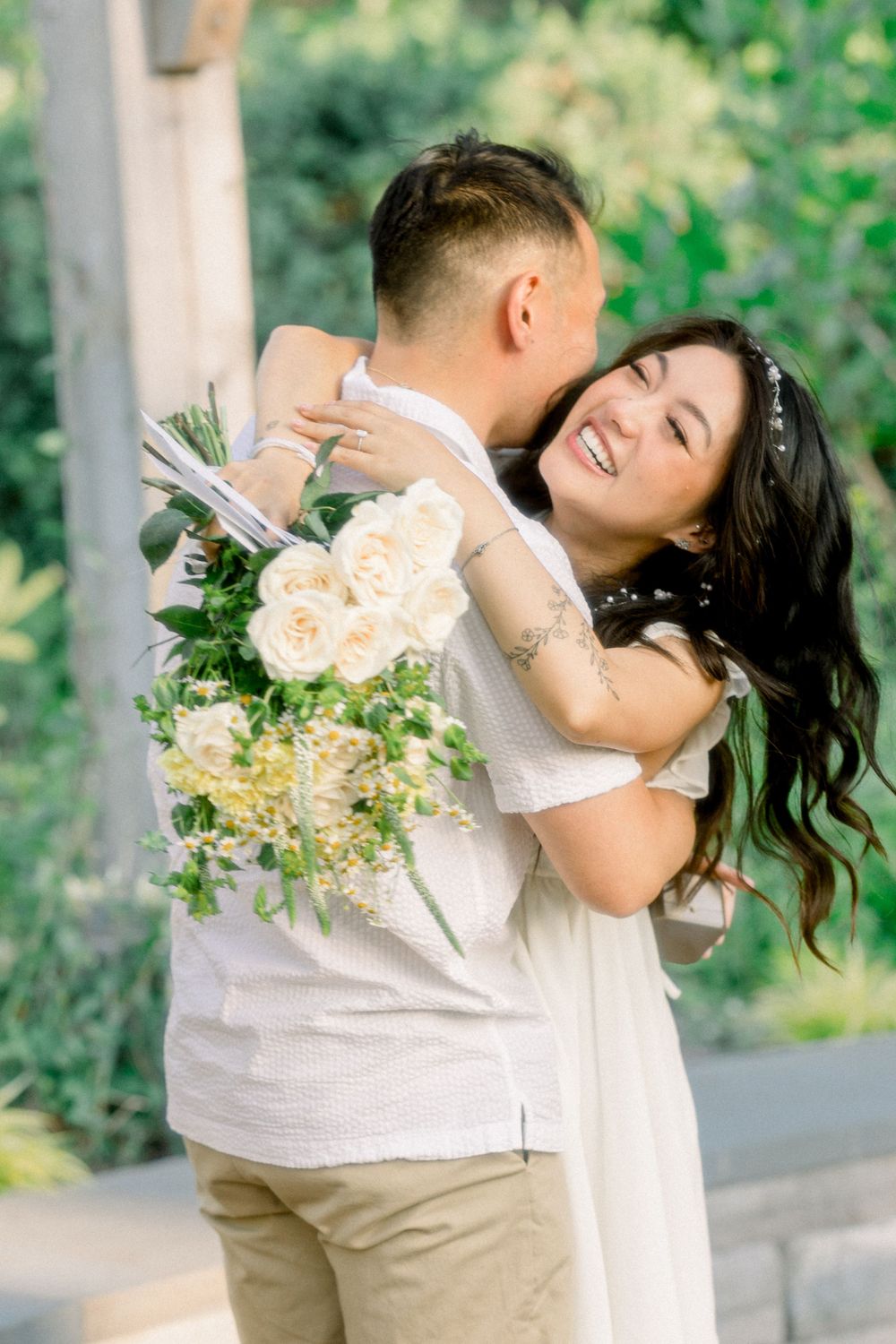 A joyful embrace captured in a sun-drenched garden with fresh flowers.