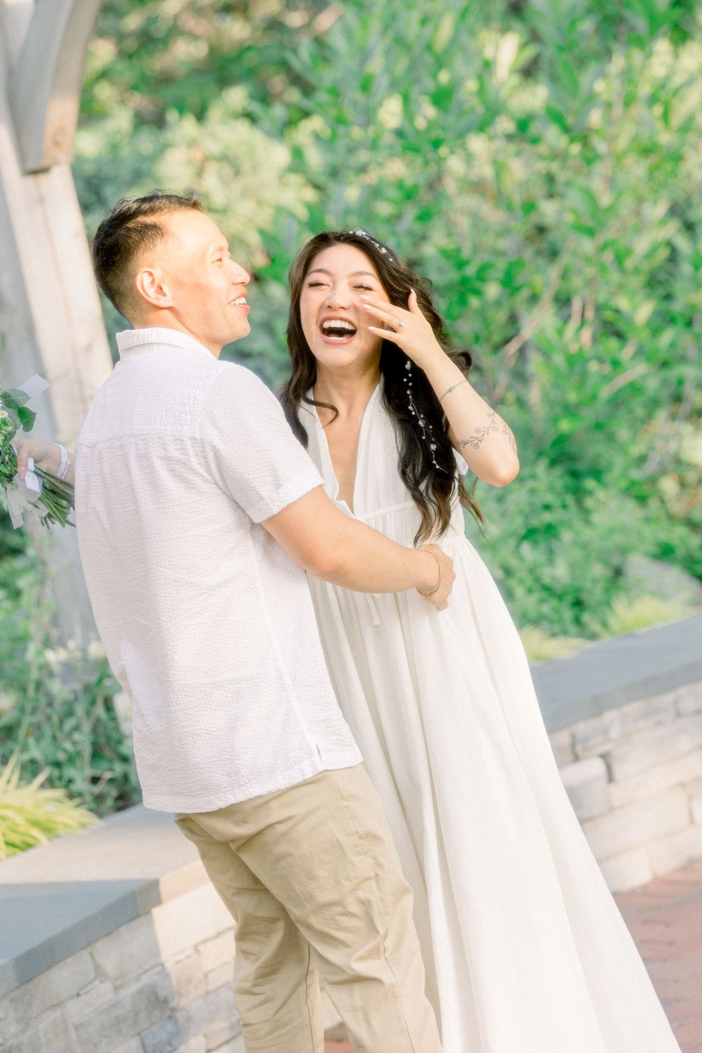 A candid moment of laughter shared between two people on a garden path.
