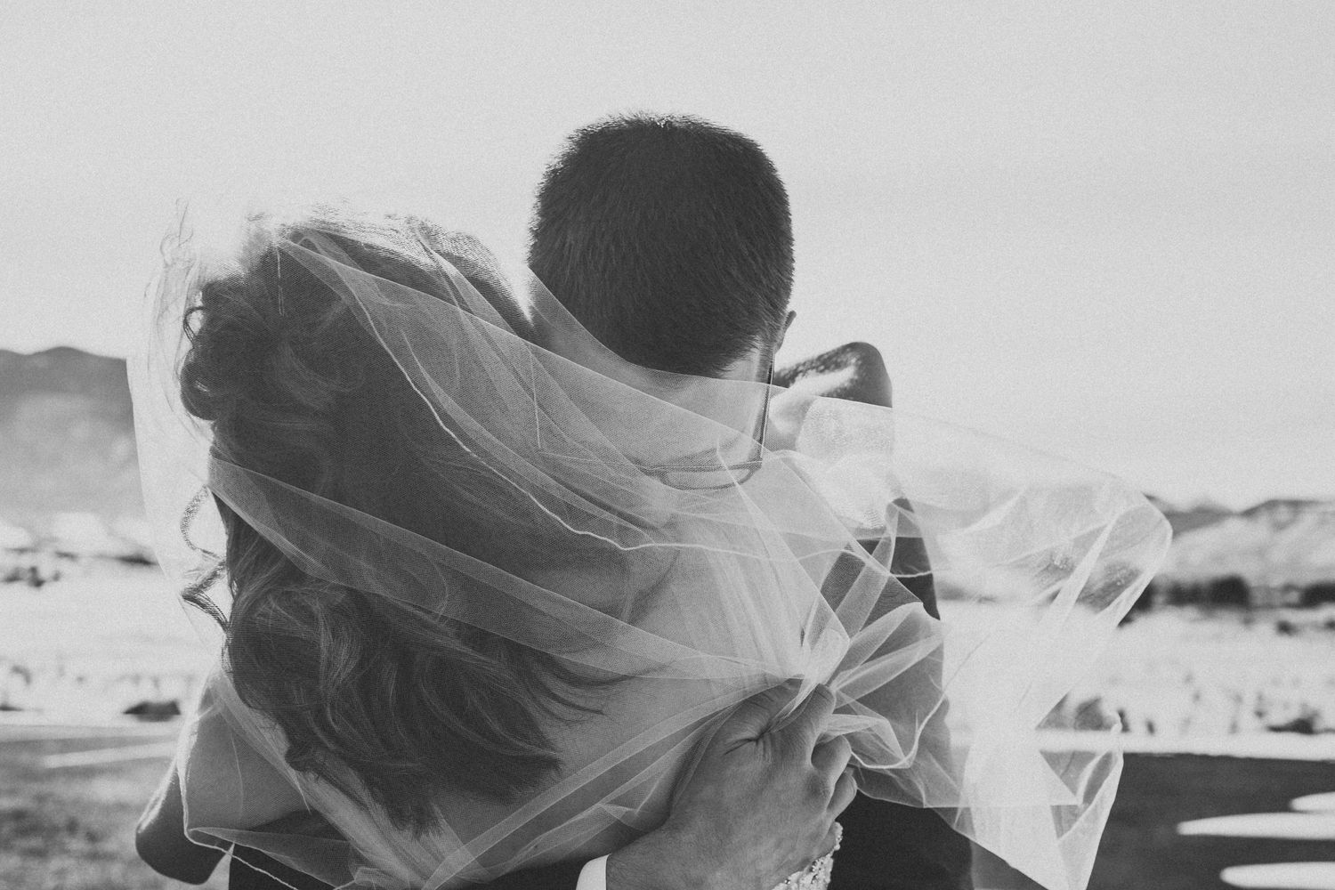 A black and white photo with flowing veil creating movement in the wind.