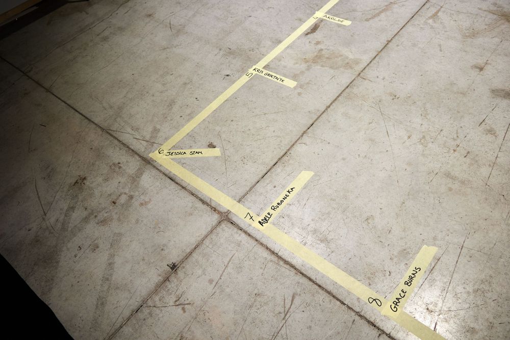 Yellow tape markings on a concrete floor showing placement positions.