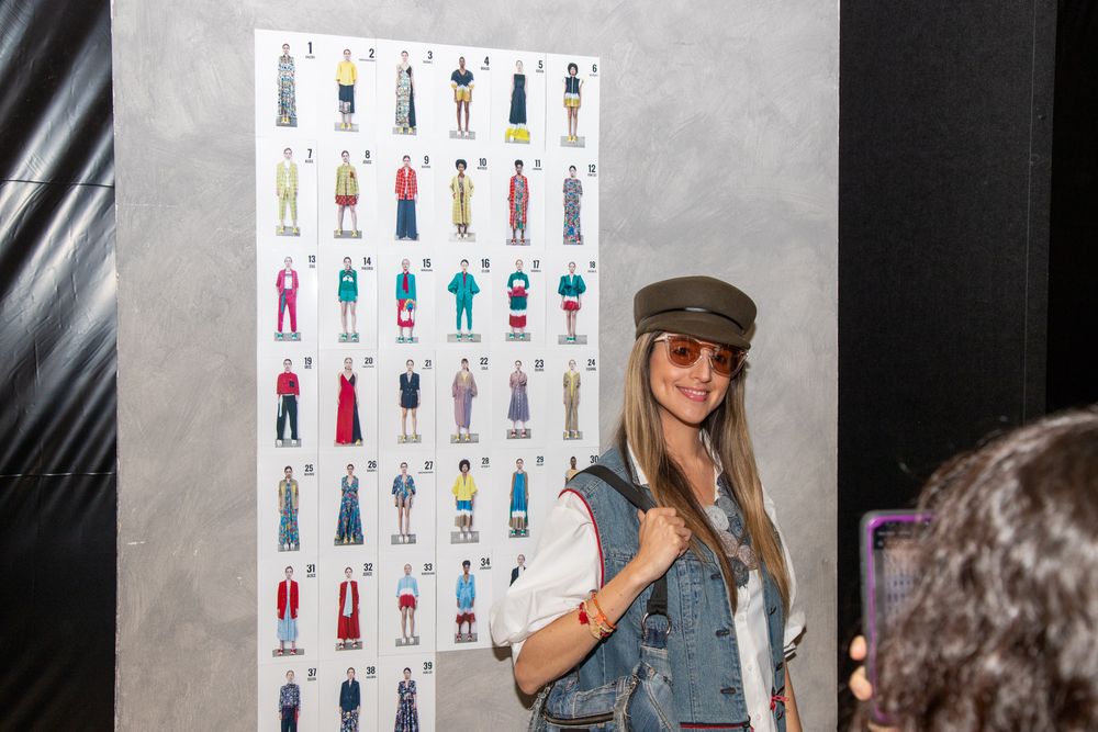 A display wall showing multiple fashion outfit illustrations and sketches.