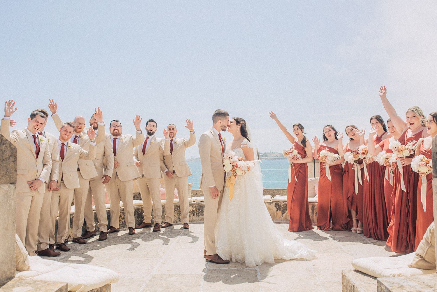 Wedding party holding luxurious white and blush bouquets at forte da Cruz. captured by a Lisbon destination wedding photographer