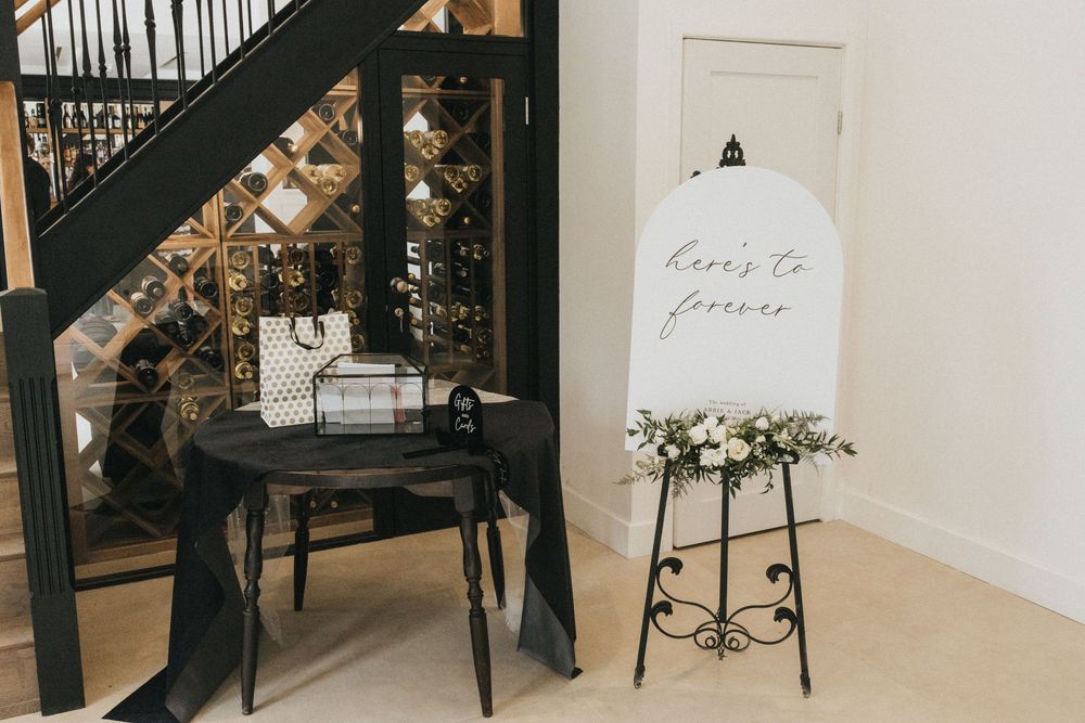 Modern event venue interior with black staircase, white walls, and elegant floral arrangements.