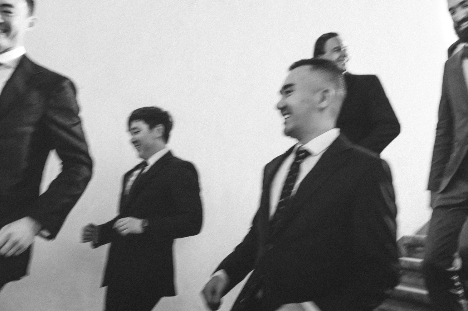 Group of men in suits and ties standing in a professional interior setting.