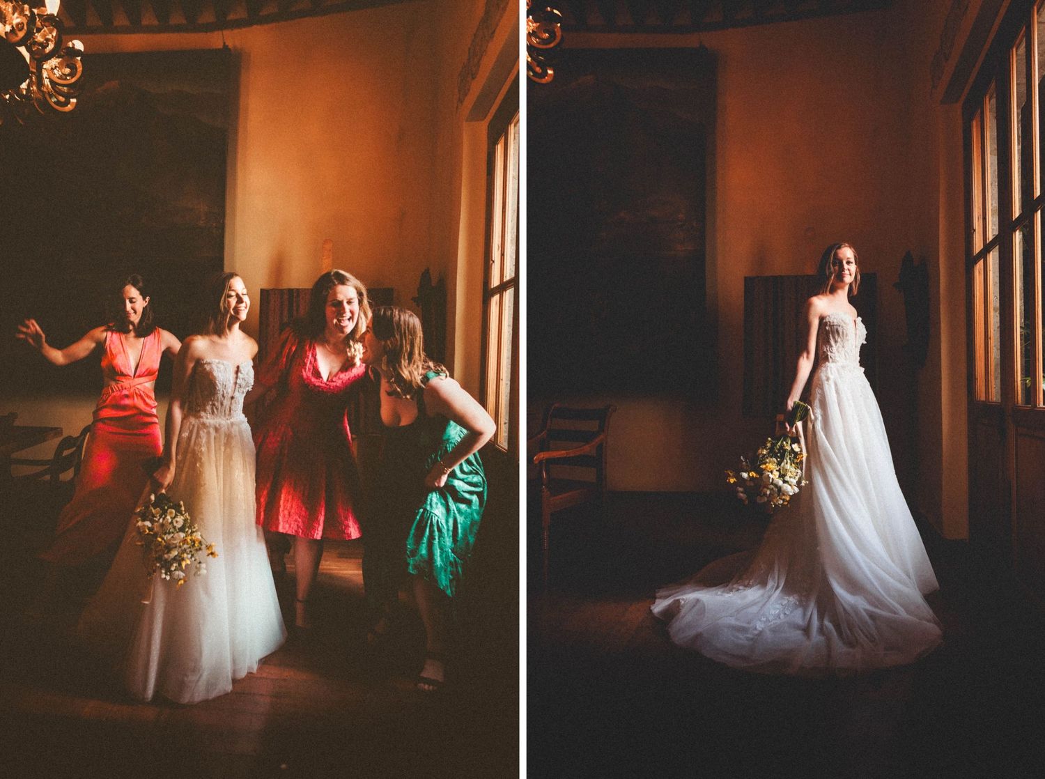 Wedding party in colorful dresses posing by large windows with warm lighting.