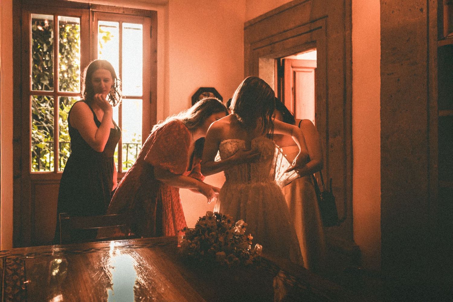 Wedding preparation scene bathed in warm sunlight through vintage windows.