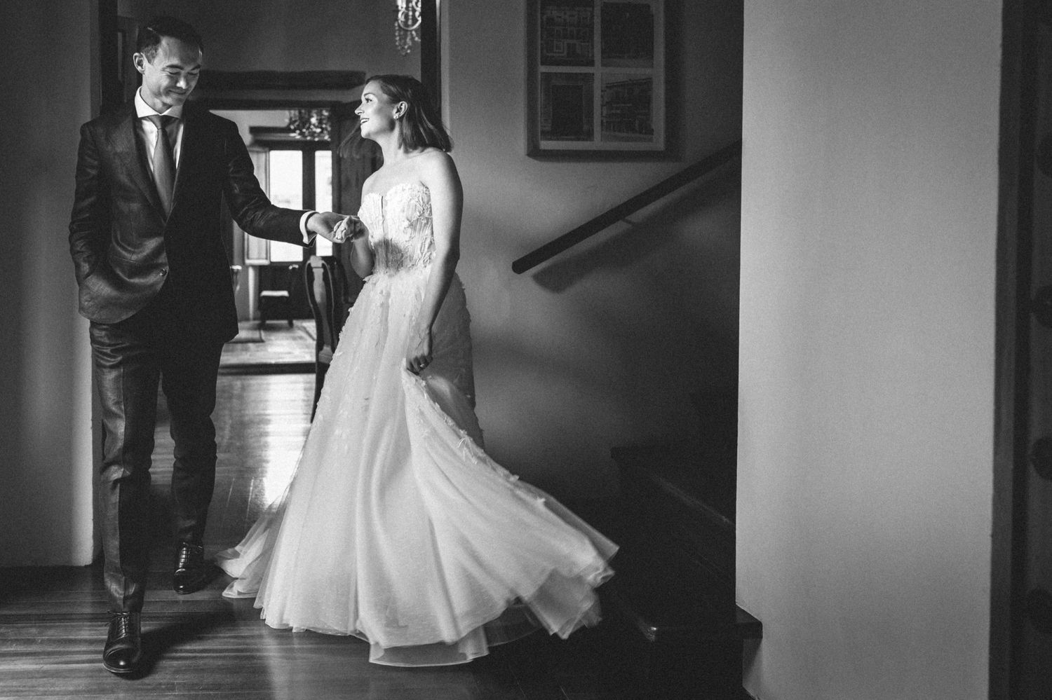 Black and white wedding portrait showing elegant couple in vintage interior setting.