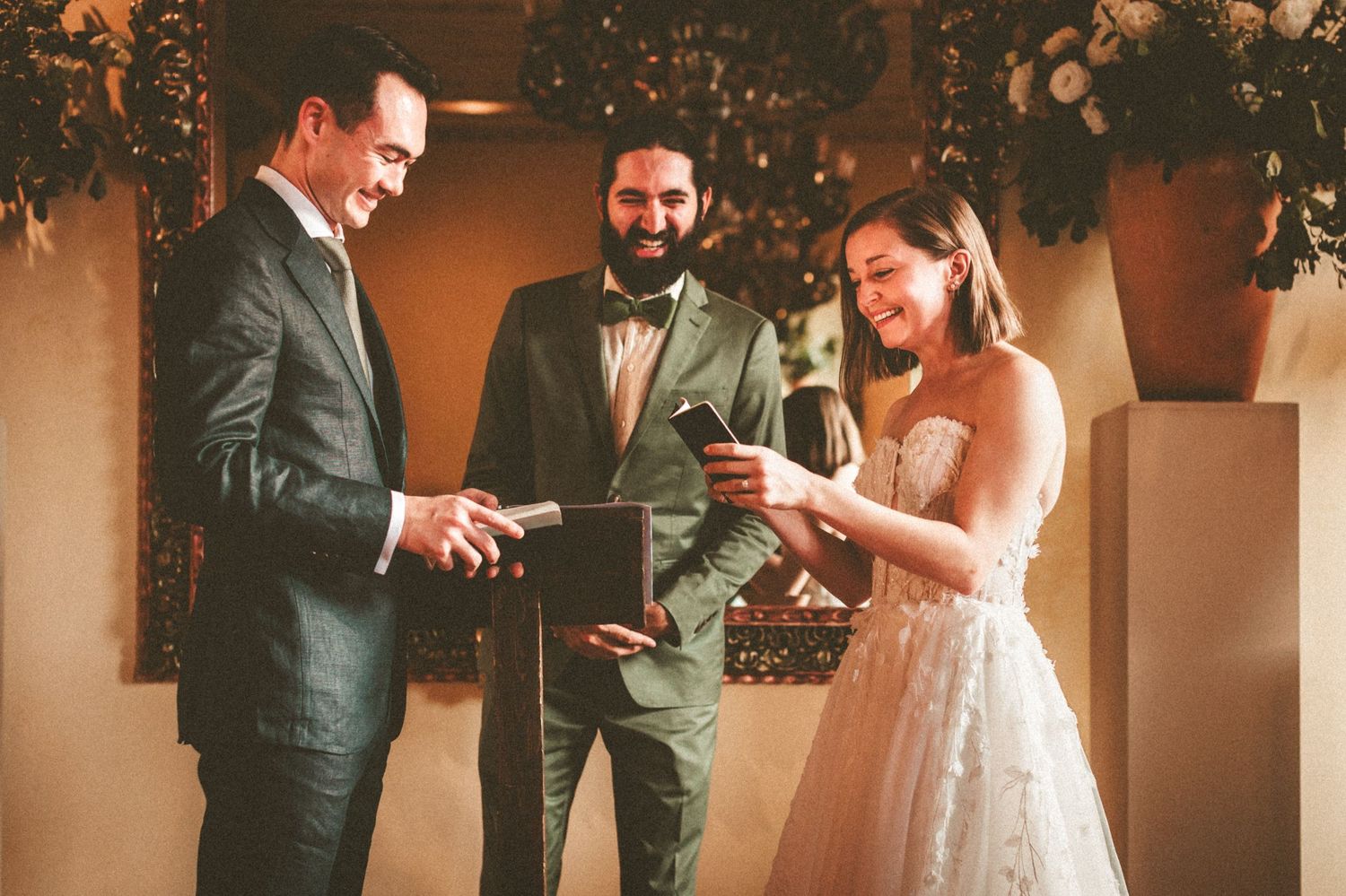 Wedding ceremony with couple exchanging vows under floral decorations.