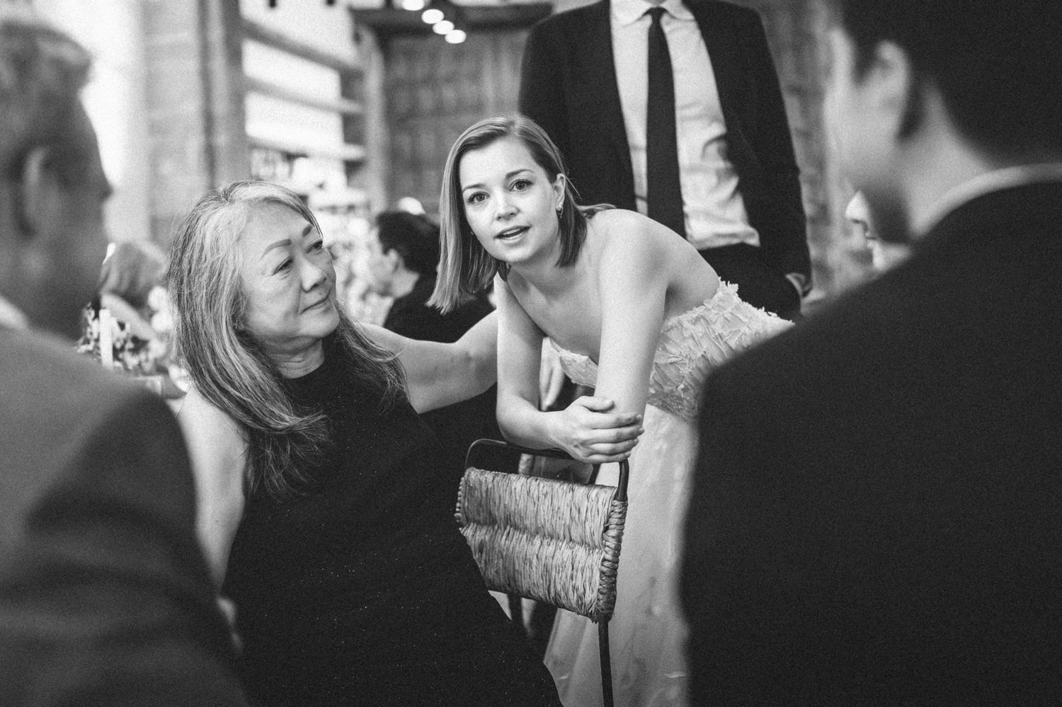 Candid black and white shots of guests mingling and socializing at an elegant evening event.