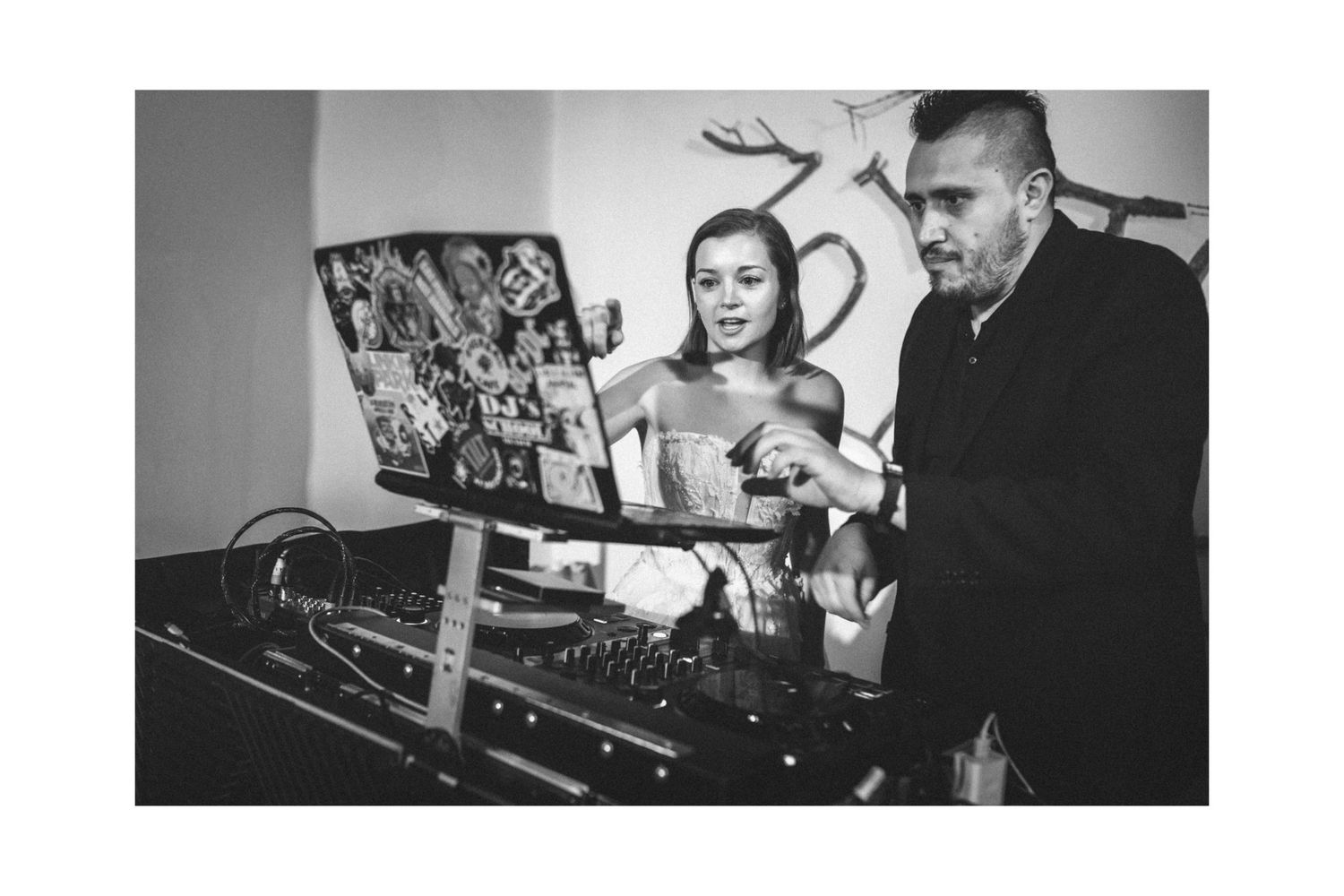 DJ performing at a nightclub event with professional audio equipment in black and white.
