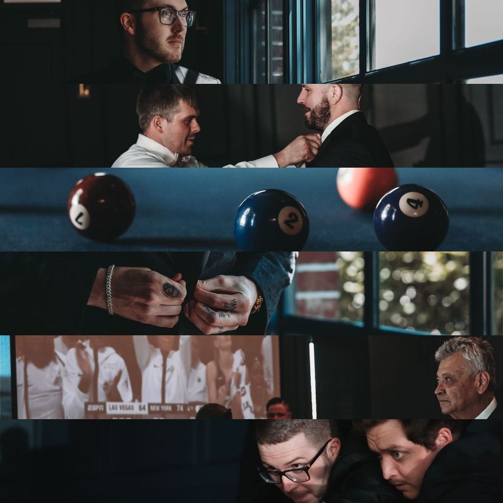 Group of colleagues in dark suits exchange documents and engage in conversations in corporate office setting.