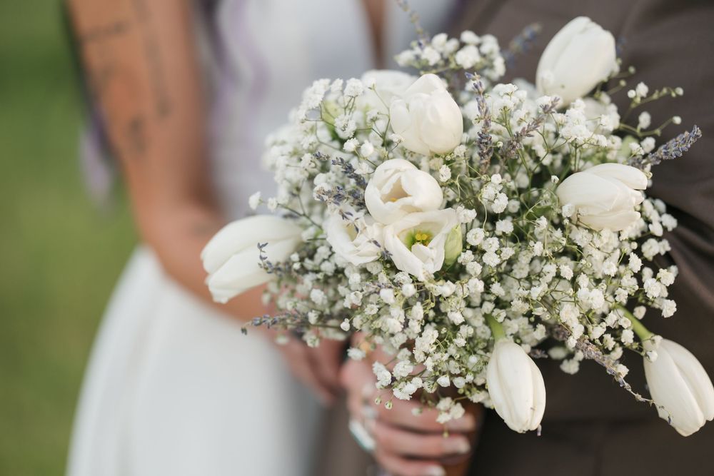 Delicate white bouquet featuring tulips and baby's breath against a soft blurred background.