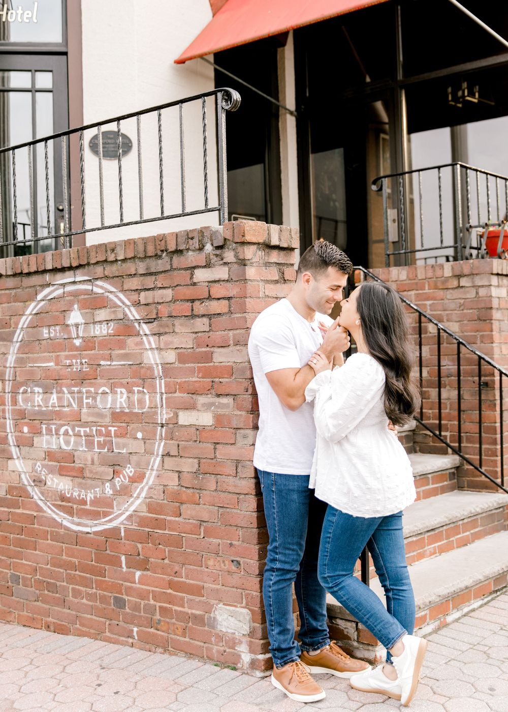 Mariela and Nick leaned against the Cranford Hotel in Cranford, New Jersey.