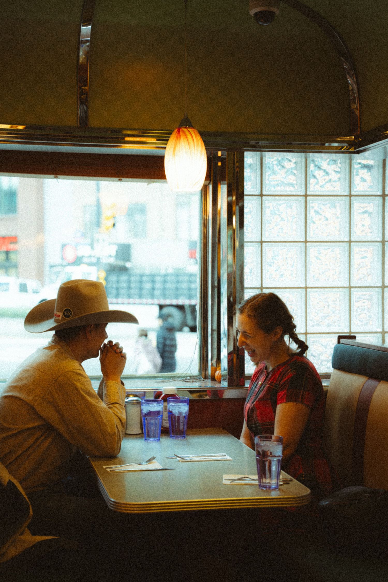 A heartfelt engagement photoshoot capturing raw emotions in a cozy café setting, featuring cinematic moments of love and connection