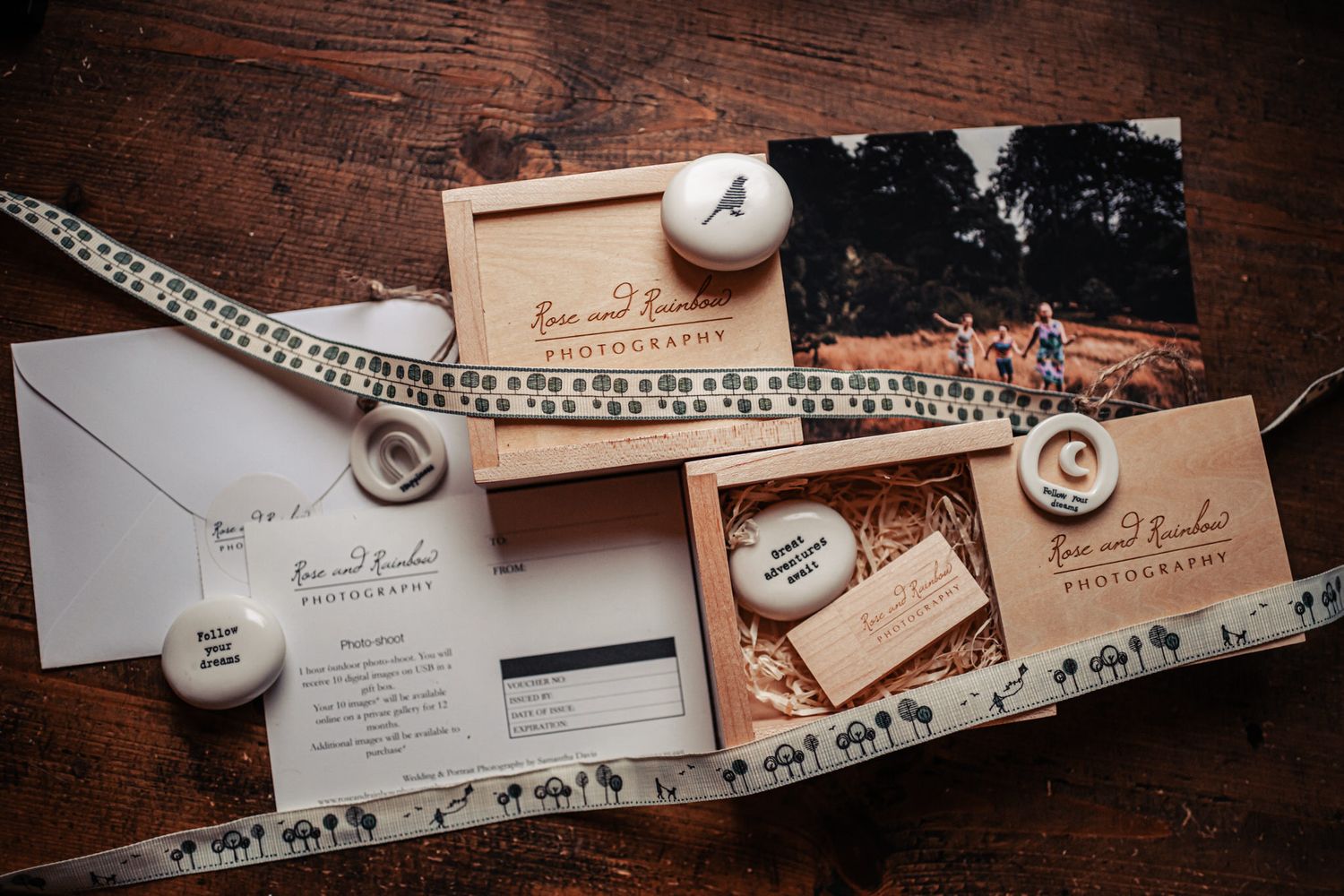 Wedding invitation suite with vintage decor elements including pearl necklace and envelopes on dark wooden surface.