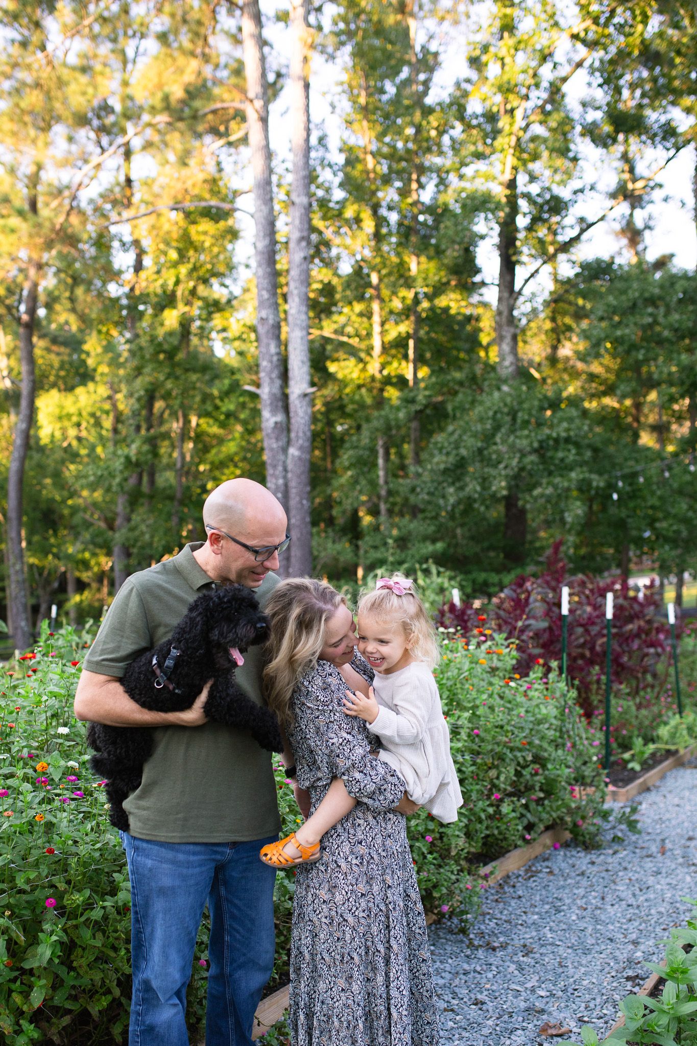 Family posing together on a garden path surrounded by lush greenery at polly's Petal Patch