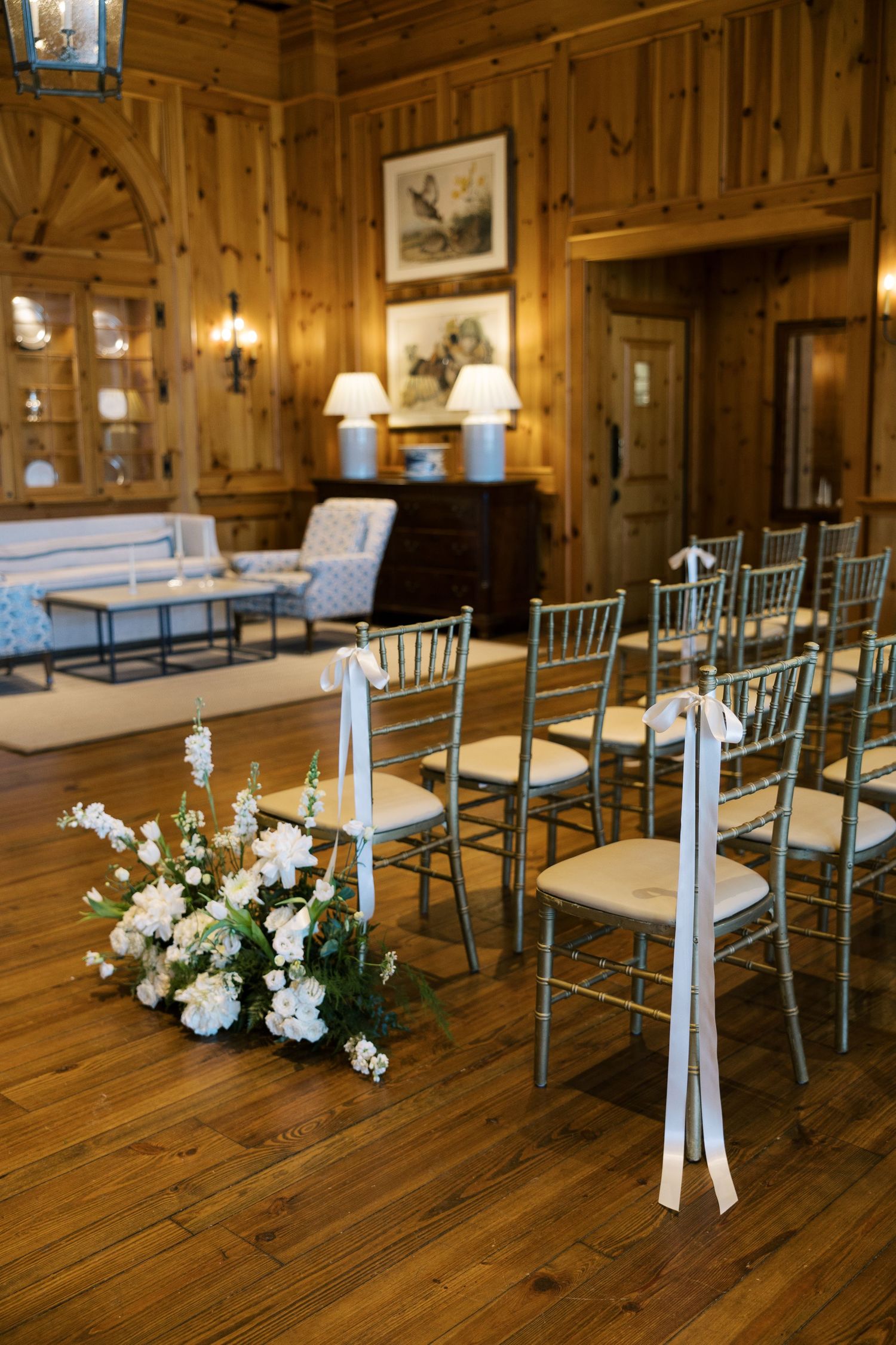 Wood-paneled ceremony room with chiavari chairs and white floral decorations.NC WEDDING PHOTOGRAPHER, LUXURY WEDDING PHOTOGRAPHER