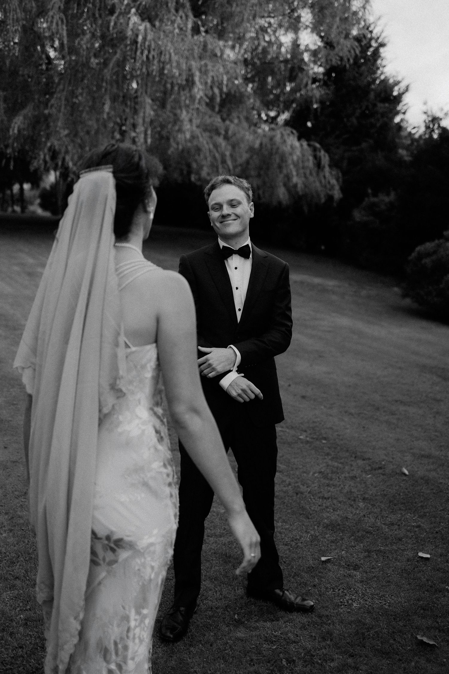 A couple embraces in a romantic black and white moment with misty mountains creating a dramatic backdrop.