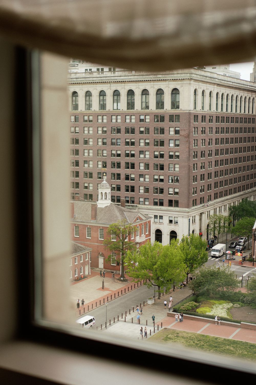 Aerial view of historic brick building and city street seen through window frame in downtown urban setting.