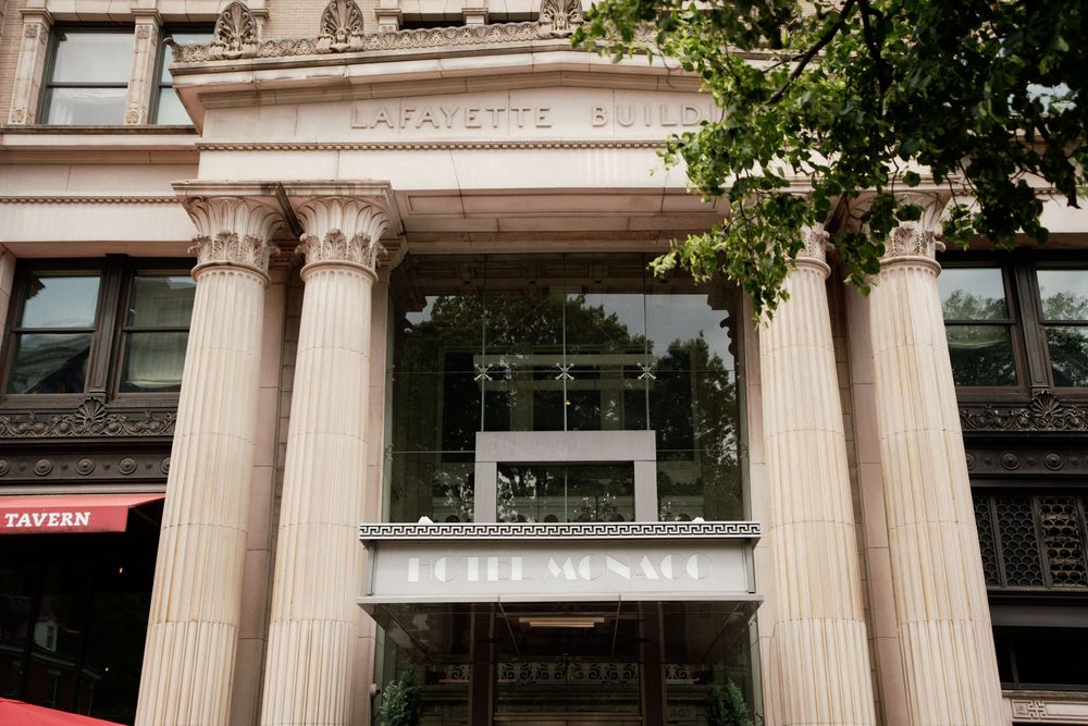 Elegant columned entrance of a historic building with classical architecture featuring white stone pillars and ornate details.
