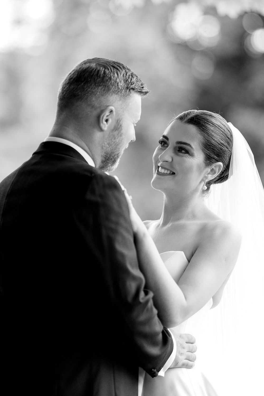A loving black and white portrait of a newlywed couple sharing an intimate moment at their wedding.