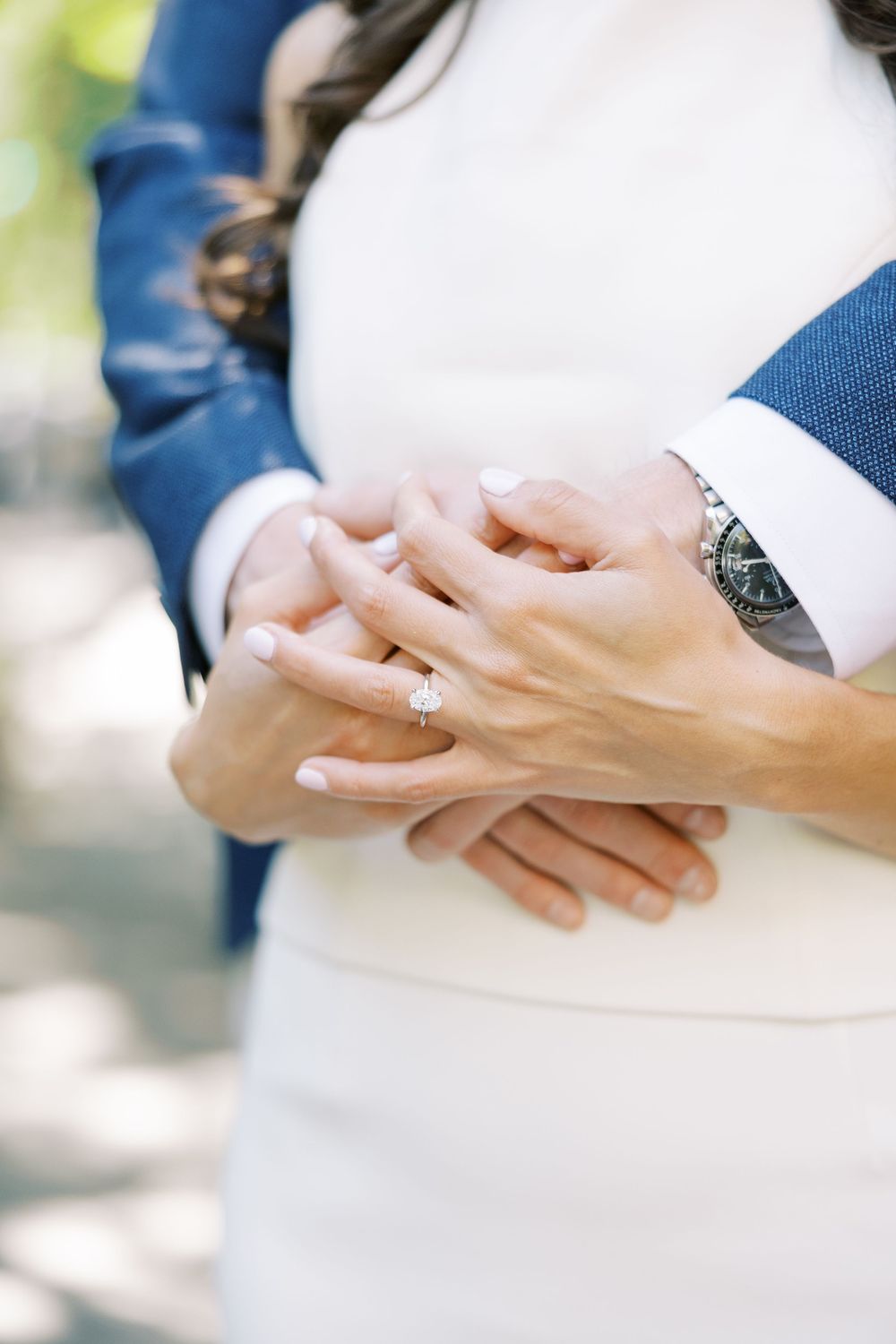 Close-up shot of hands with engagement ring in soft natural lighting in New York City.