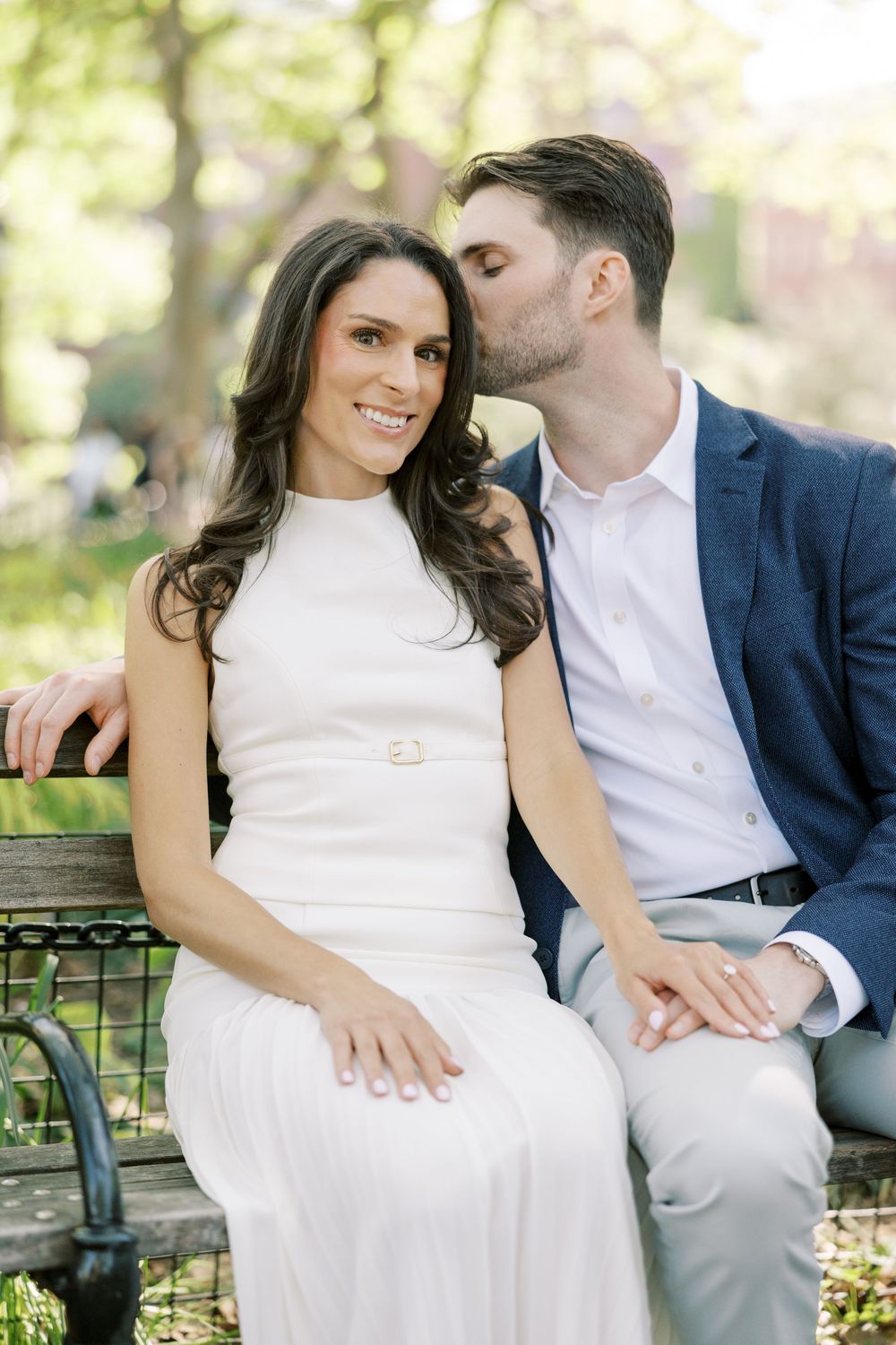 Intimate moment between couple on park bench wearing formal attire in New York City.