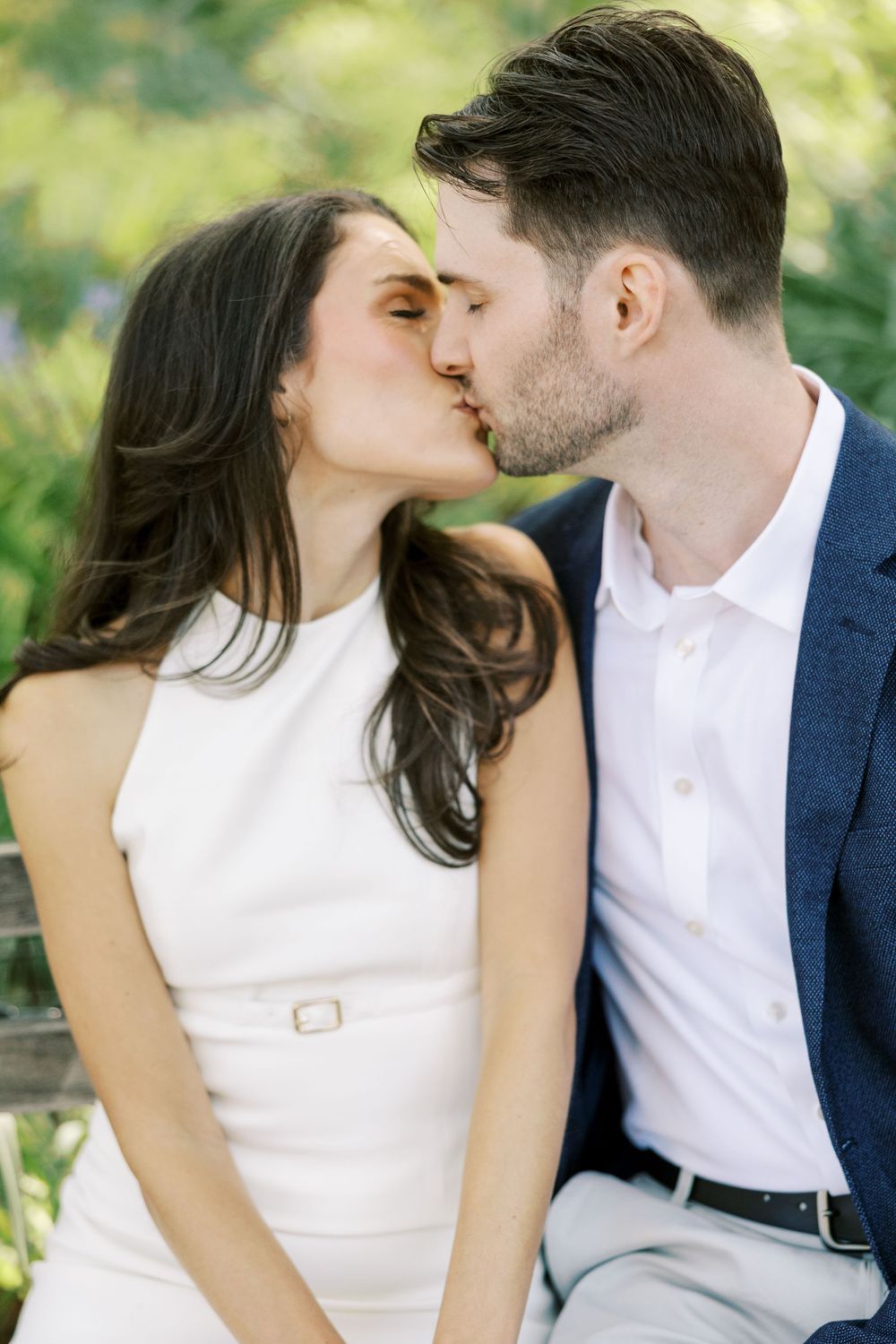 A romantic outdoor portrait of a couple sharing a tender kiss in formal attire in New York City.