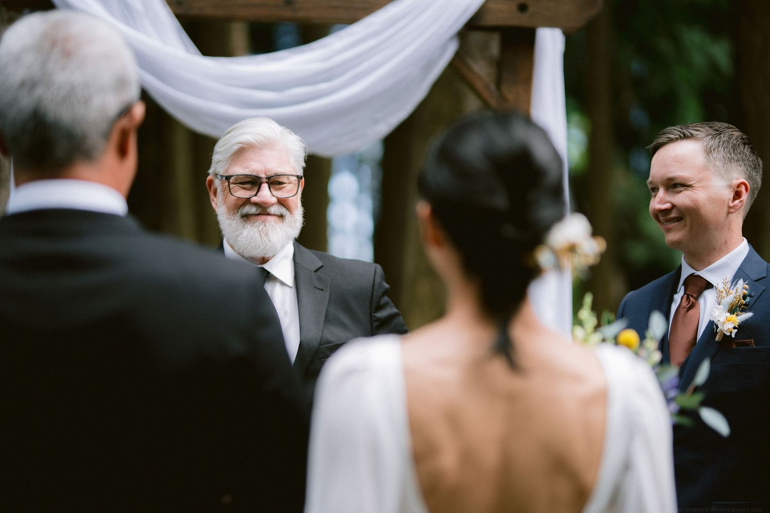 A joyful outdoor wedding ceremony as participants share a warm moment together during the proceedings.