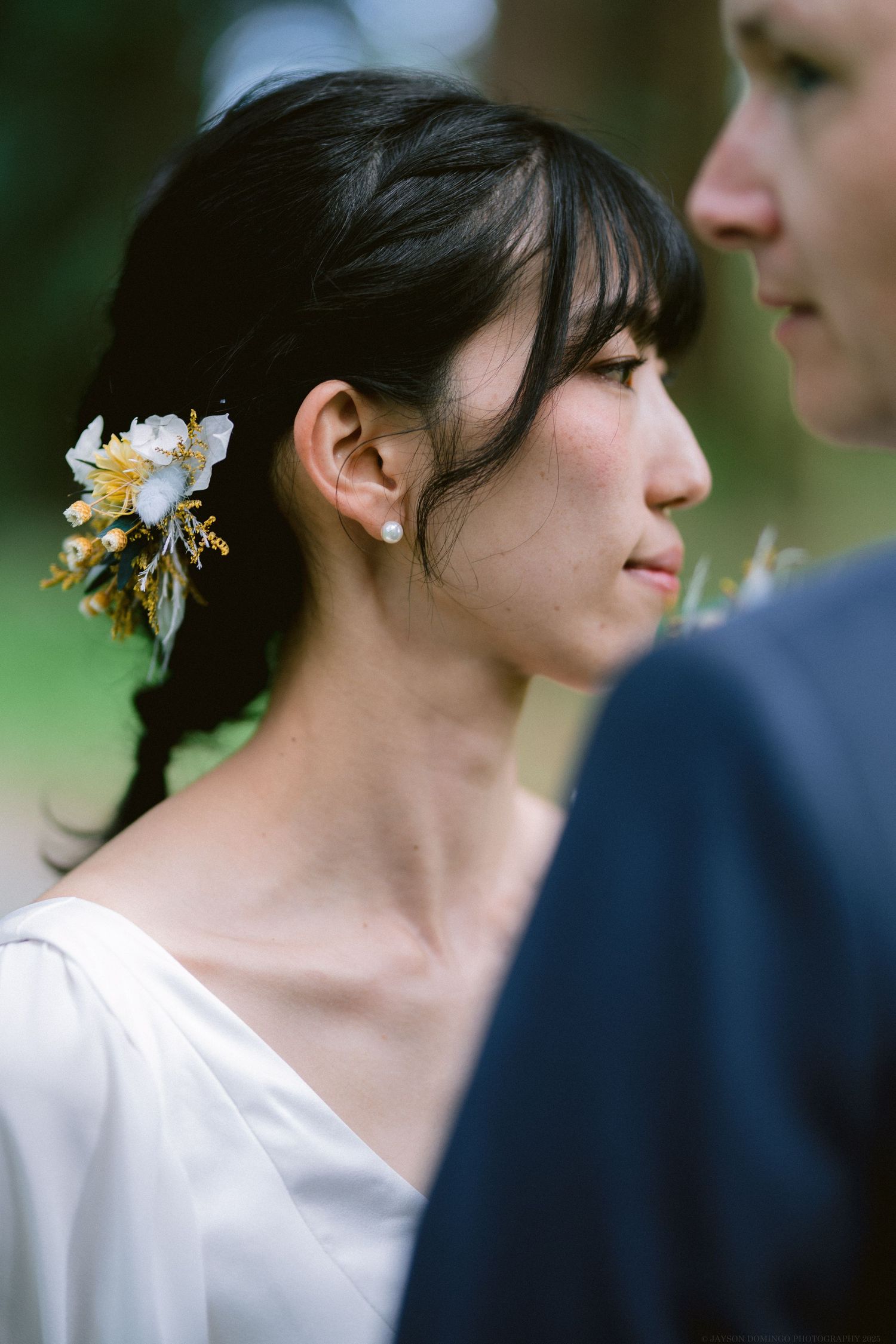 A close-up detail of delicate white floral hair accessories against dark hair.
