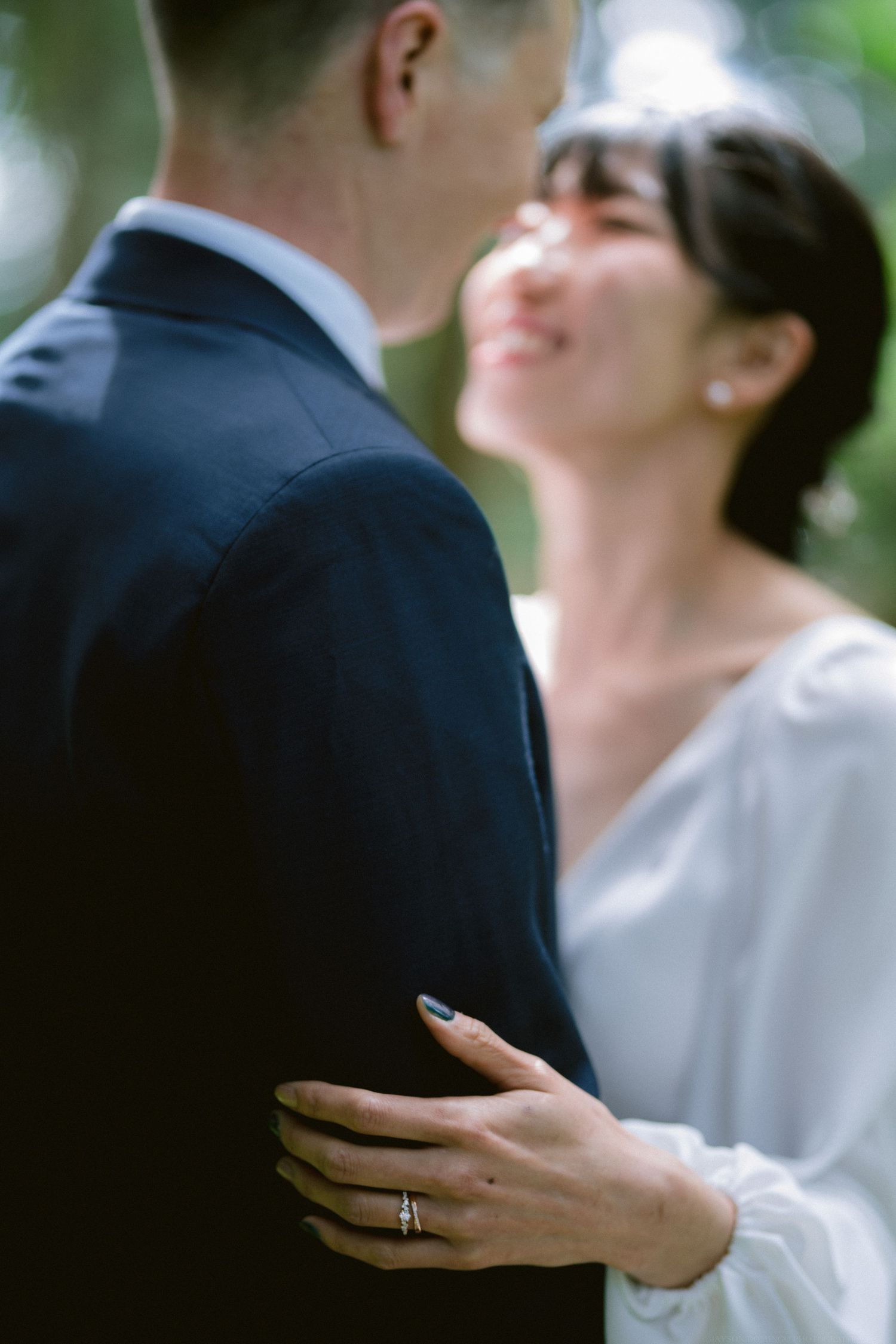A tender moment between newlyweds showing a close-up of hands with wedding ring.