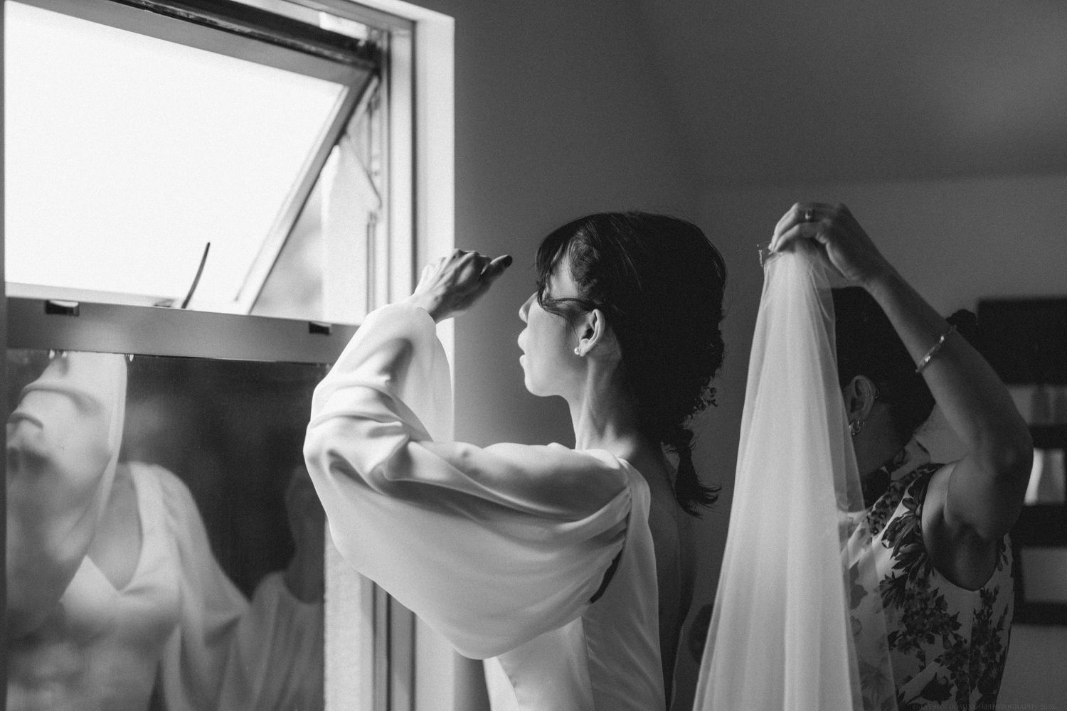 Black and white photograph showing window light streaming into a room with reflective surfaces.