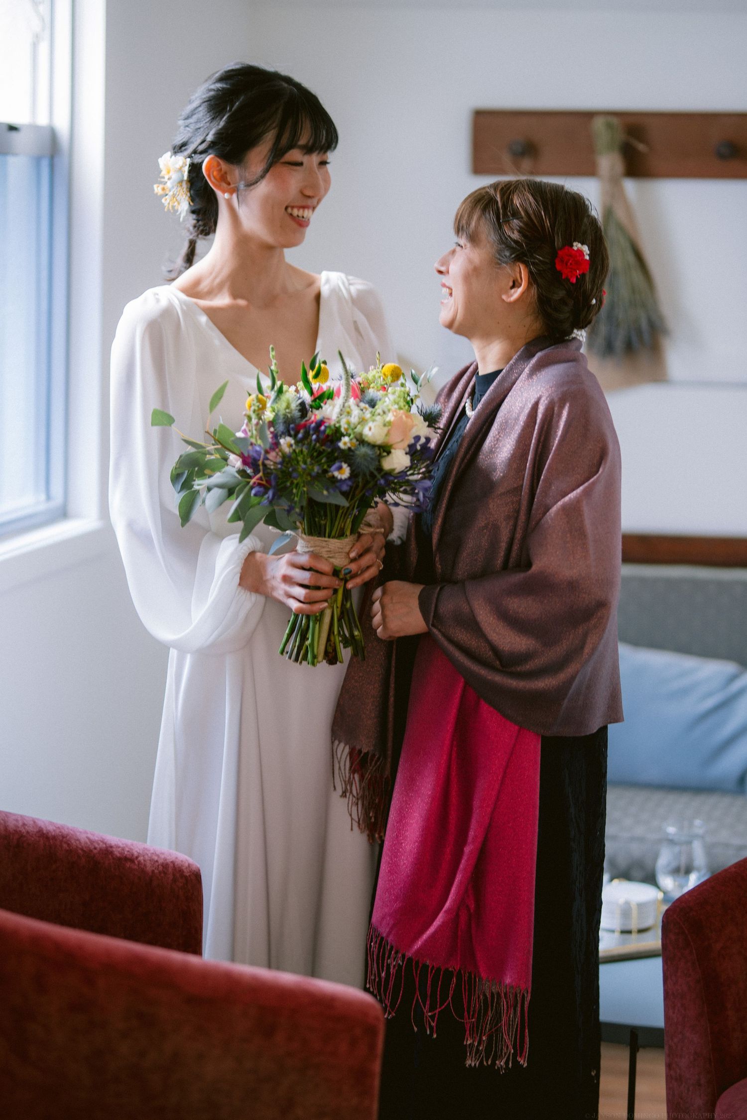 Joyful moment with colorful wildflower bouquet in sunlit room.