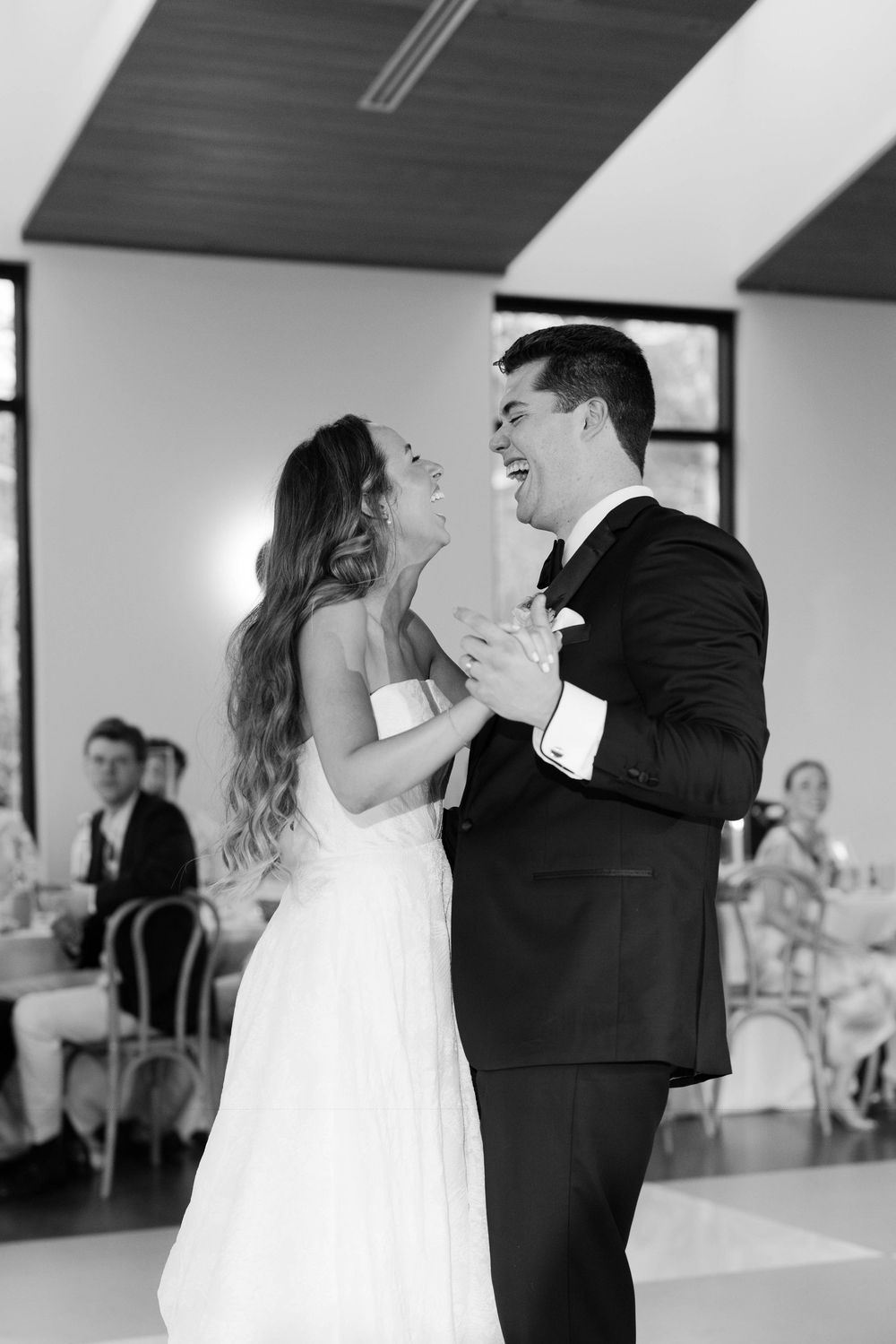 A bride and groom share a joyful first dance together at their wedding reception.