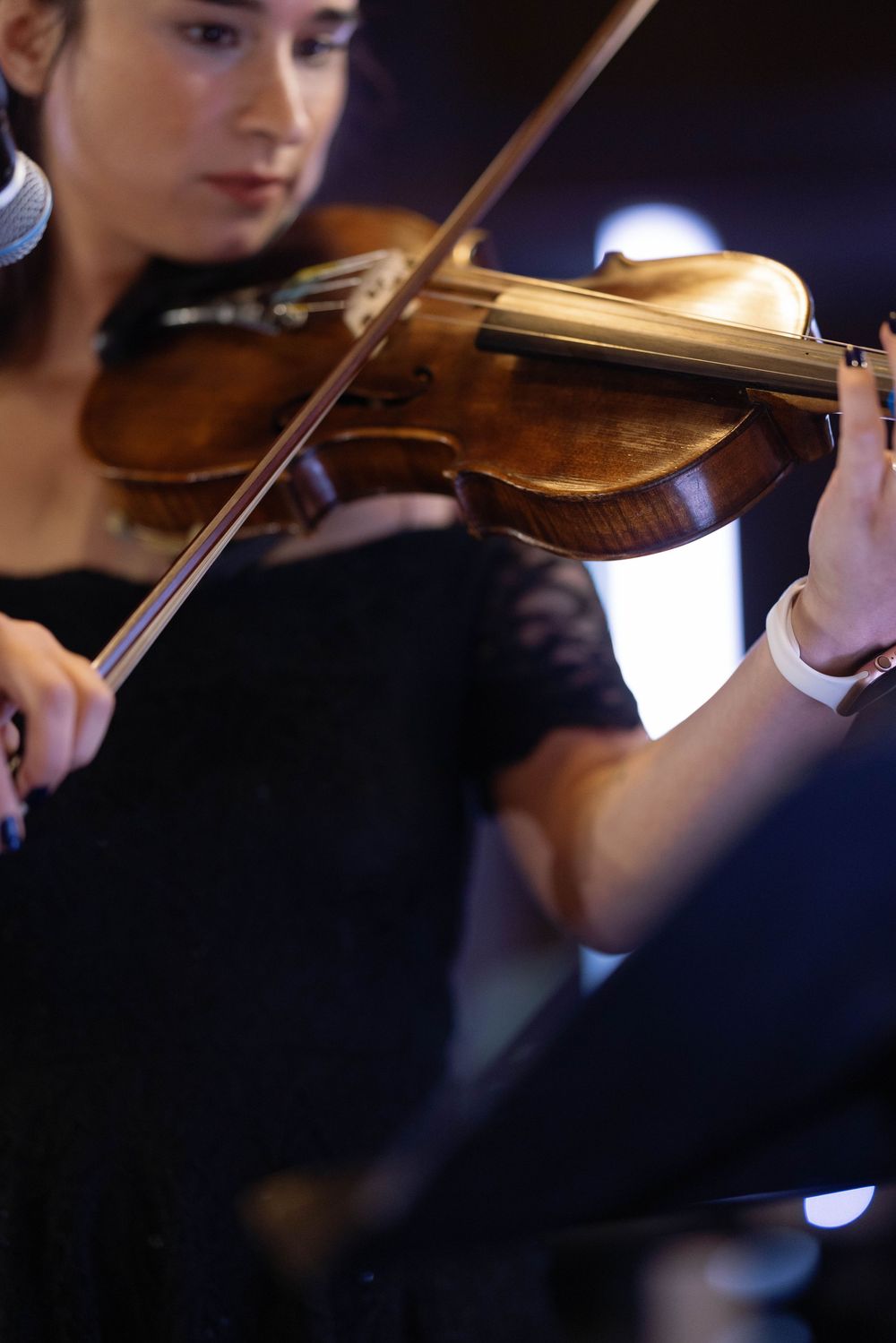 Close-up sequence of a violinist performing with their instrument in formal concert attire.
