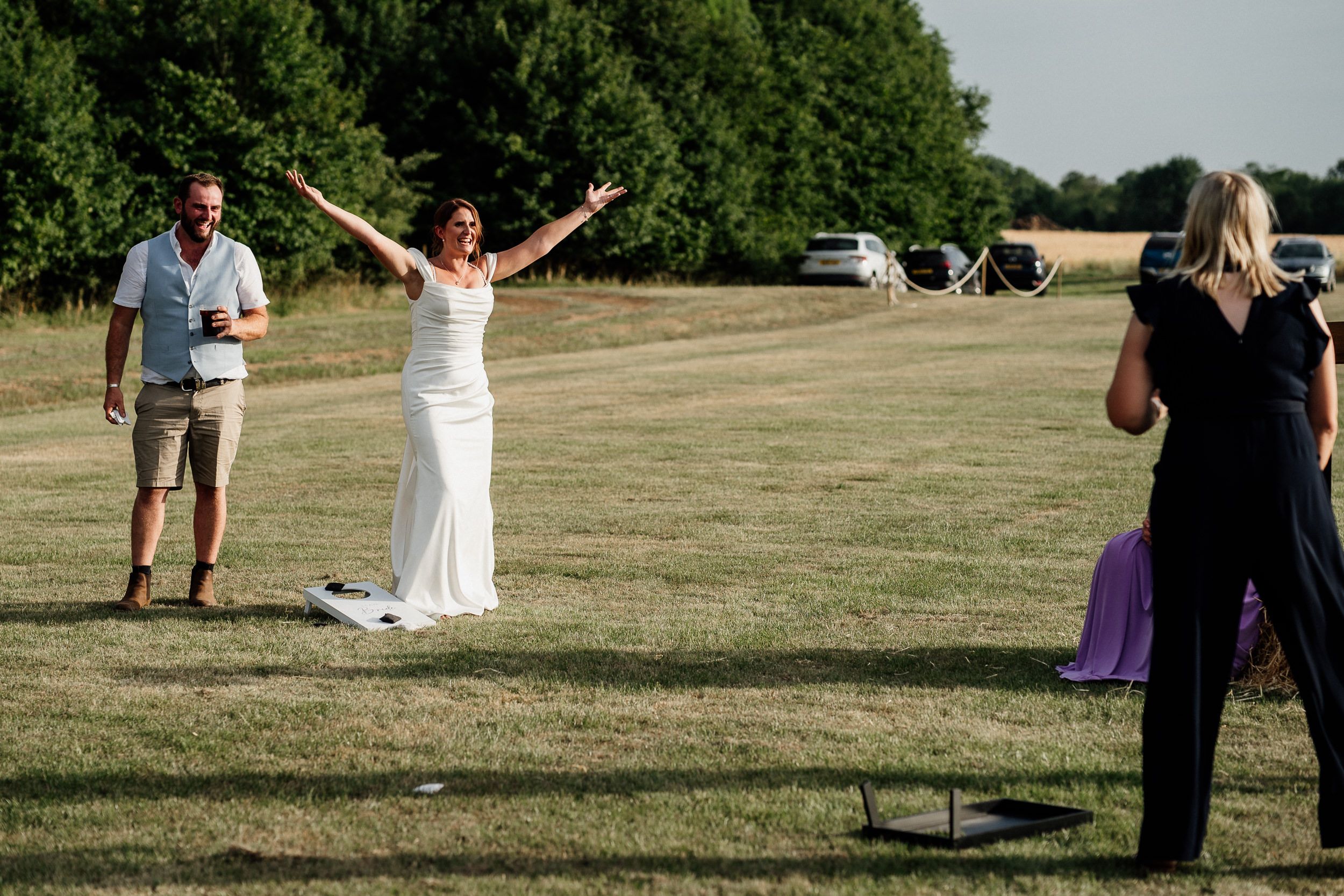 Celebratory wedding moment captured on a sunny grassy lawn with guests watching the festivities.