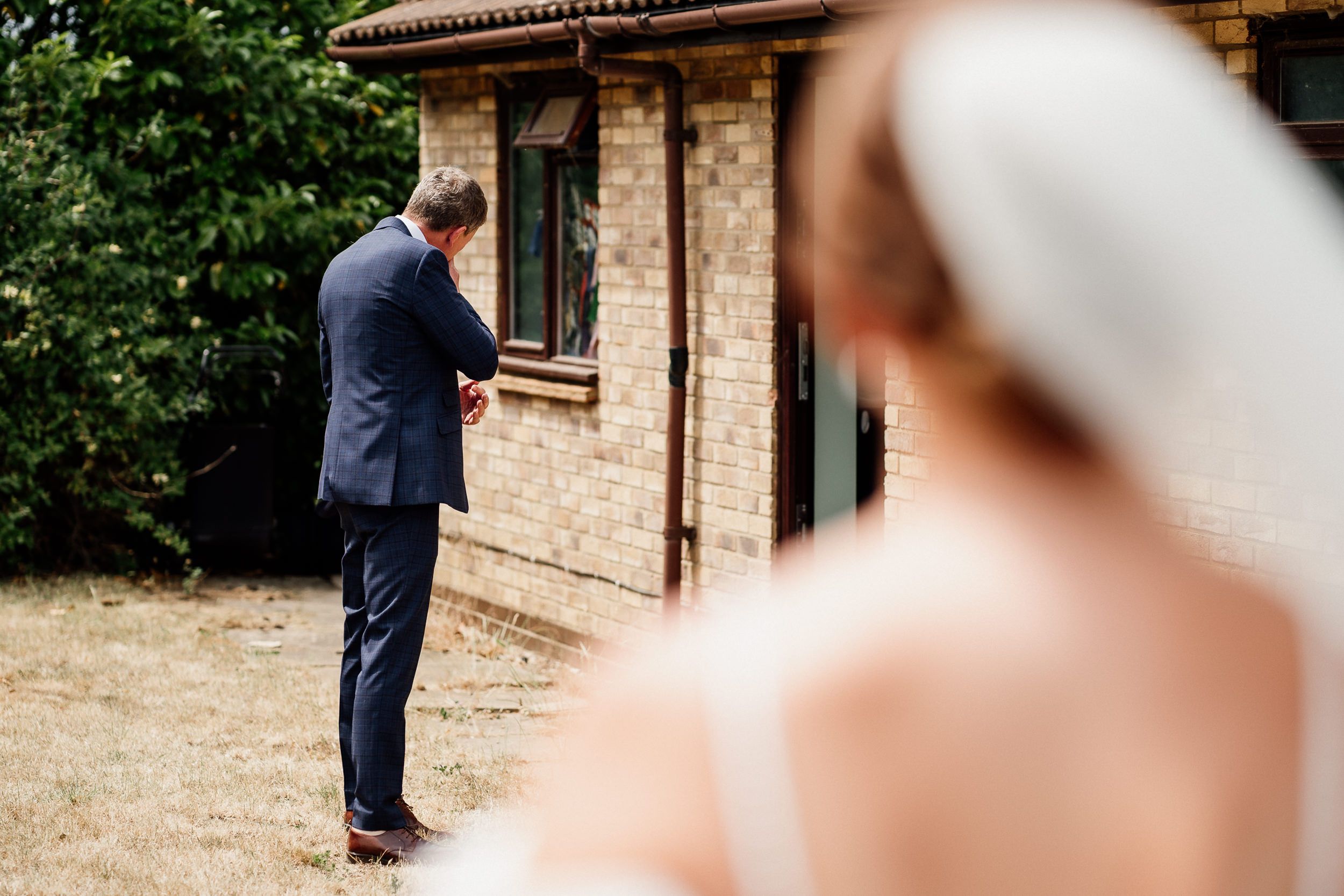 Through a veil, a couple stands together during an intimate outdoor wedding ceremony at a rustic venue.